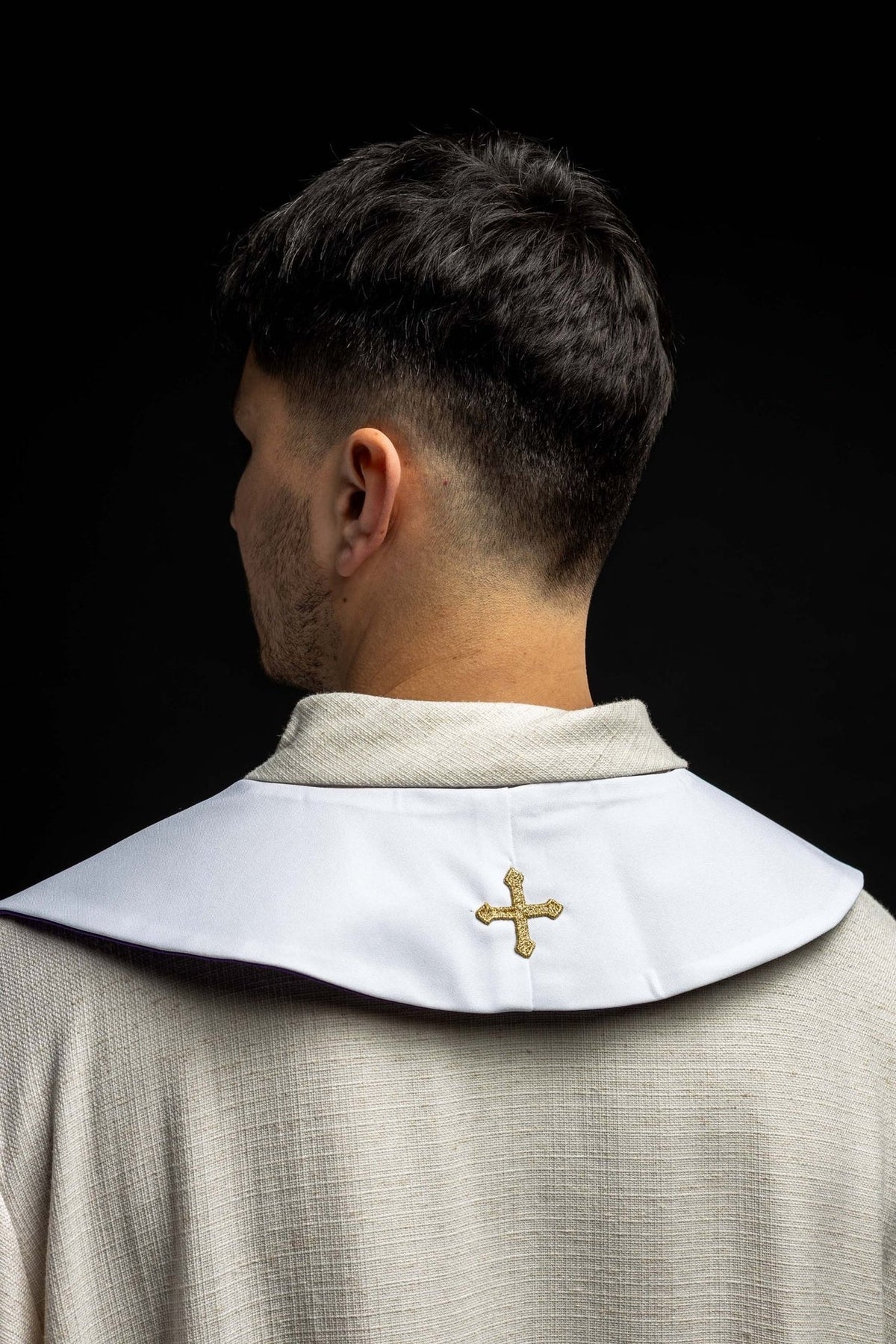 White stole back view with gold embroidered cross and purple edging