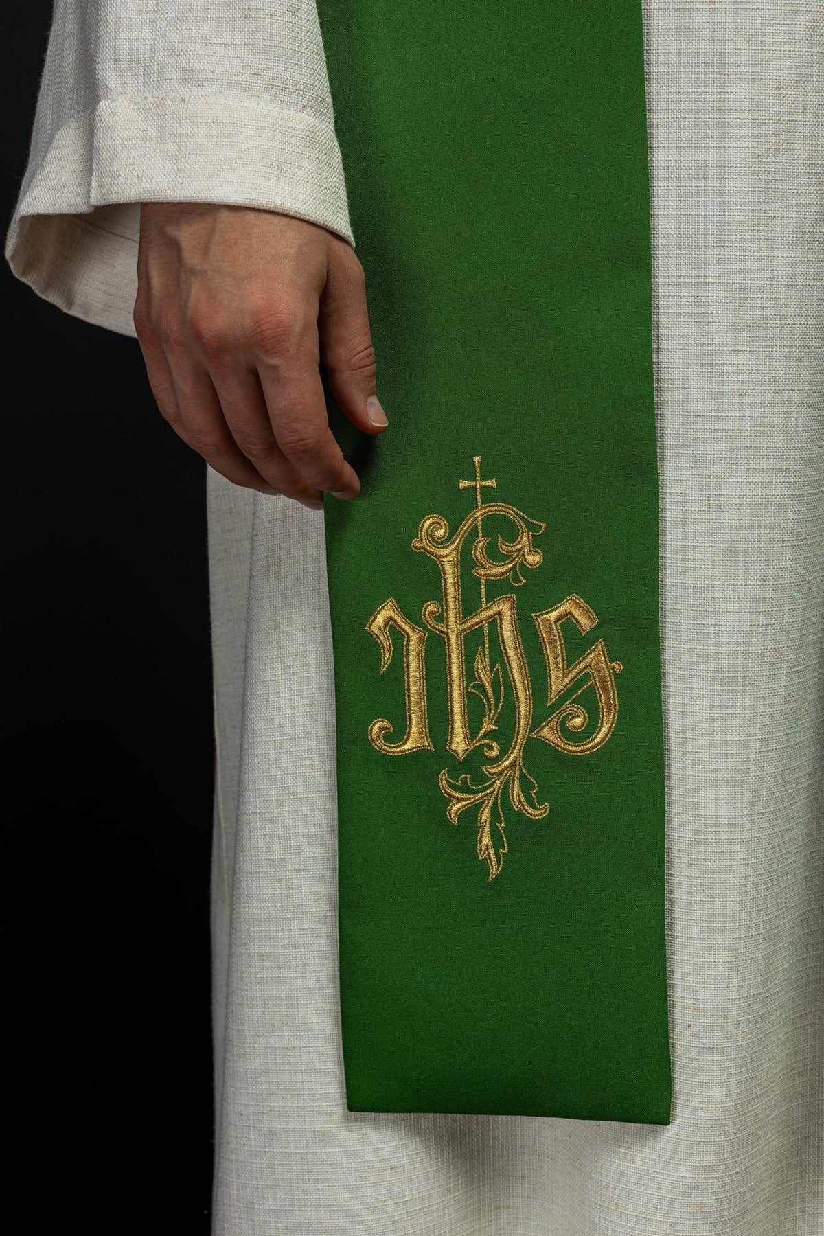 Green stole close-up showing gold IHS embroidery and fabric texture