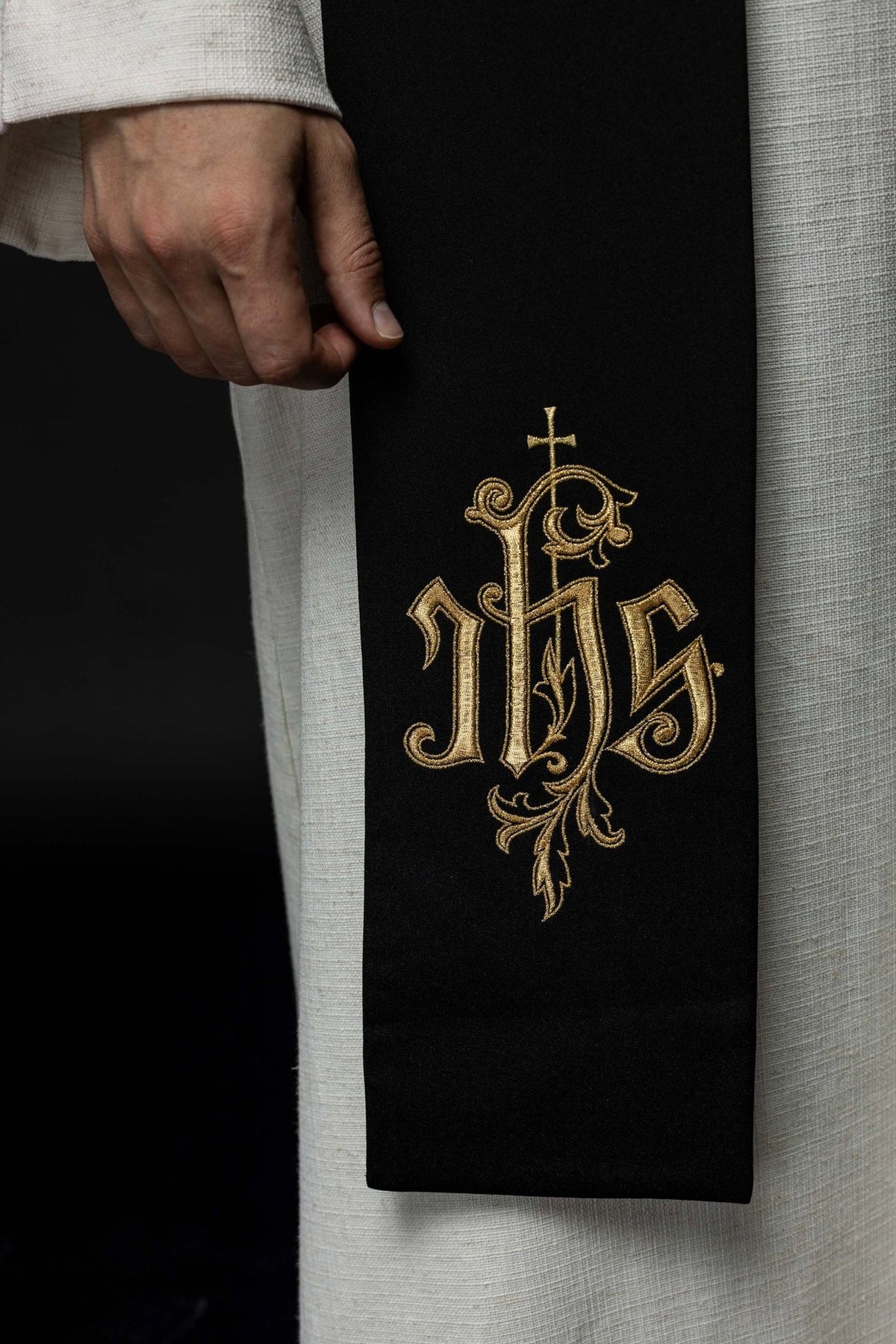 IHS stole close-up showing gold embroidered IHS motif on black fabric
