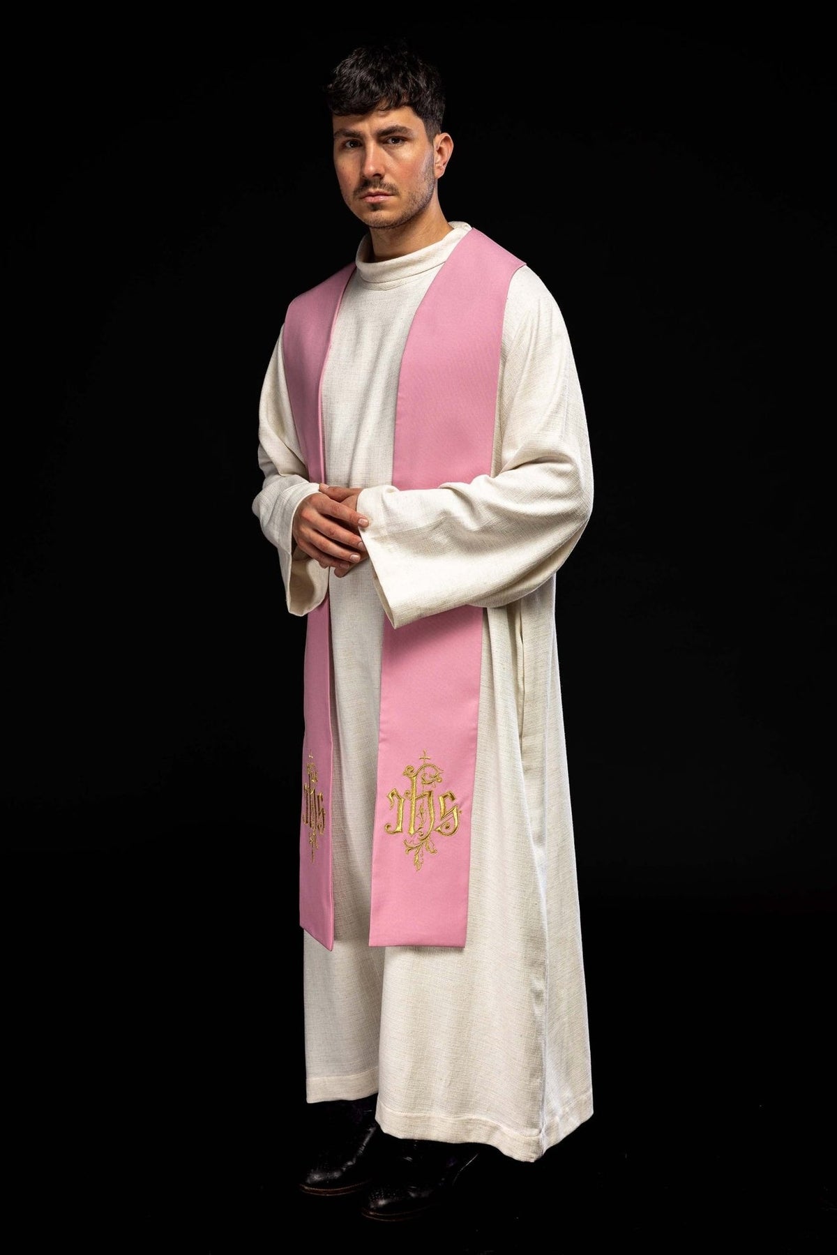 Rose priest stole worn at an angle, showing IHS embroidery