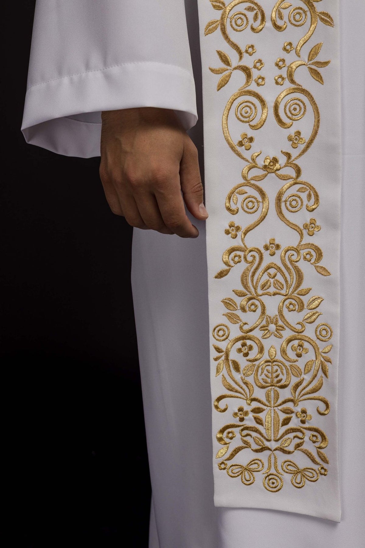 White stole close-up showing intricate embroidered gold floral scrollwork