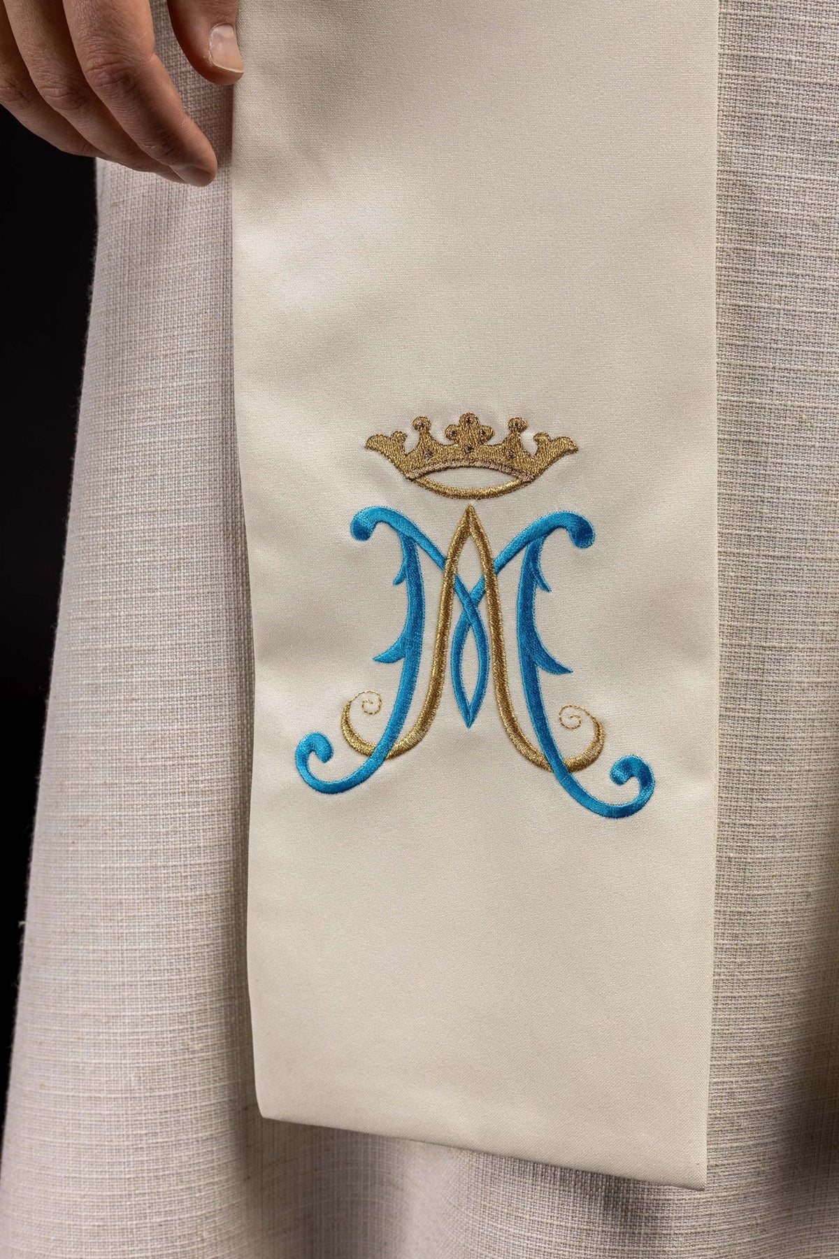 Ecru Marian stole close-up showing embroidered blue and silver crowned Marian symbol