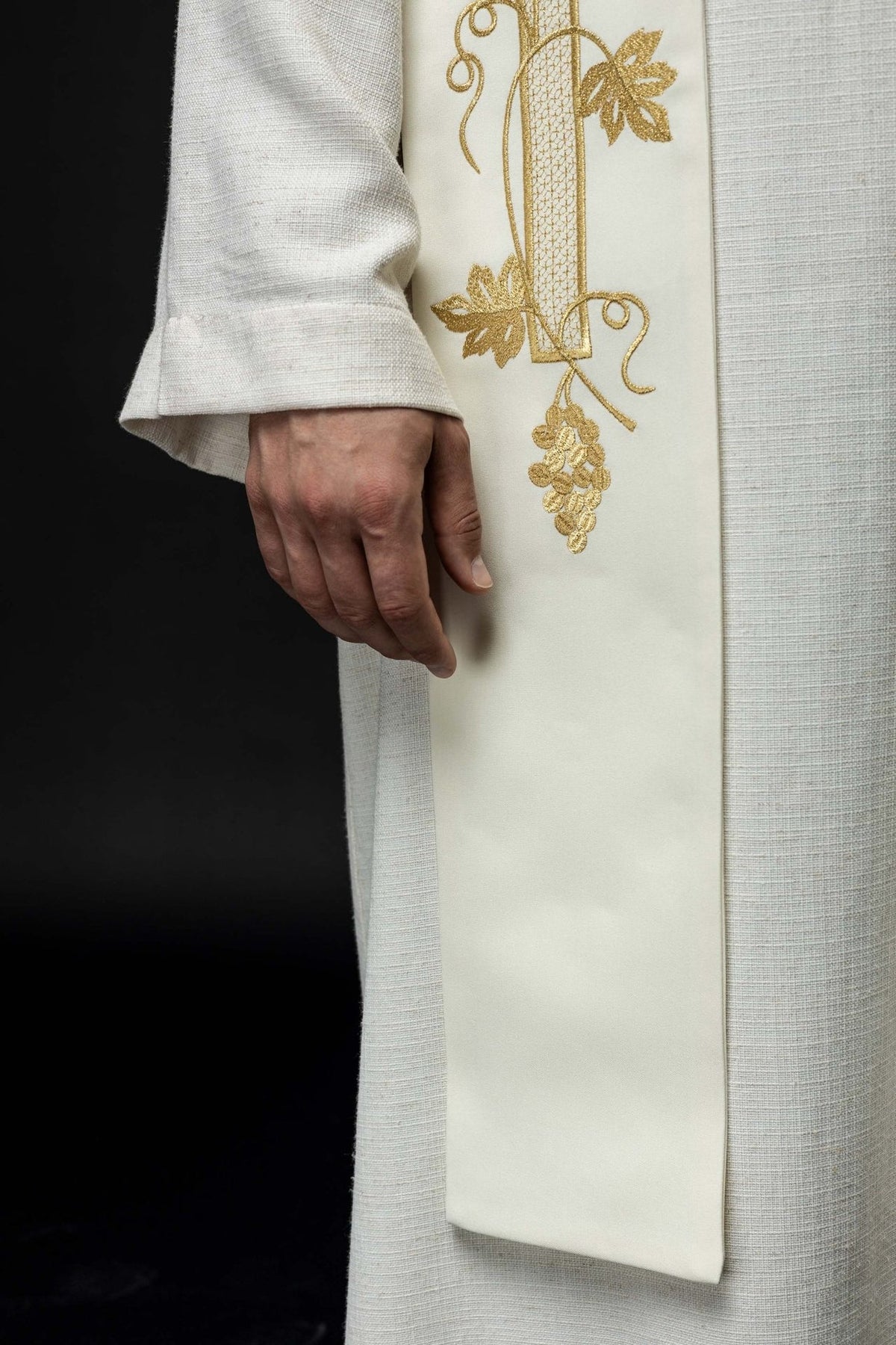 Ecru stole close-up showing gold floral and grape embroidery near the lower edge