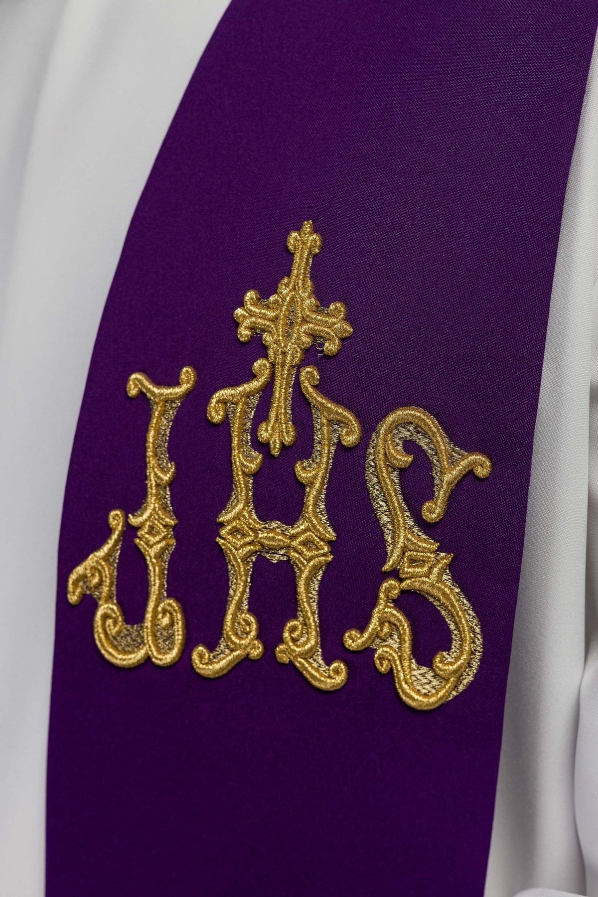 Purple priest stole close-up with gold IHS and cross embroidery
