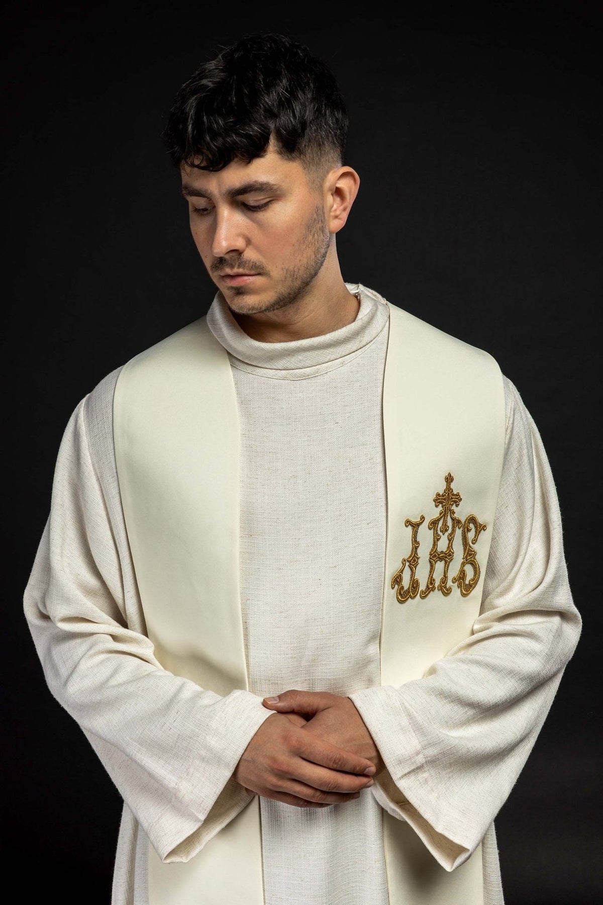 Ecru priest stole worn, upper front view showing gold IHS embroidery