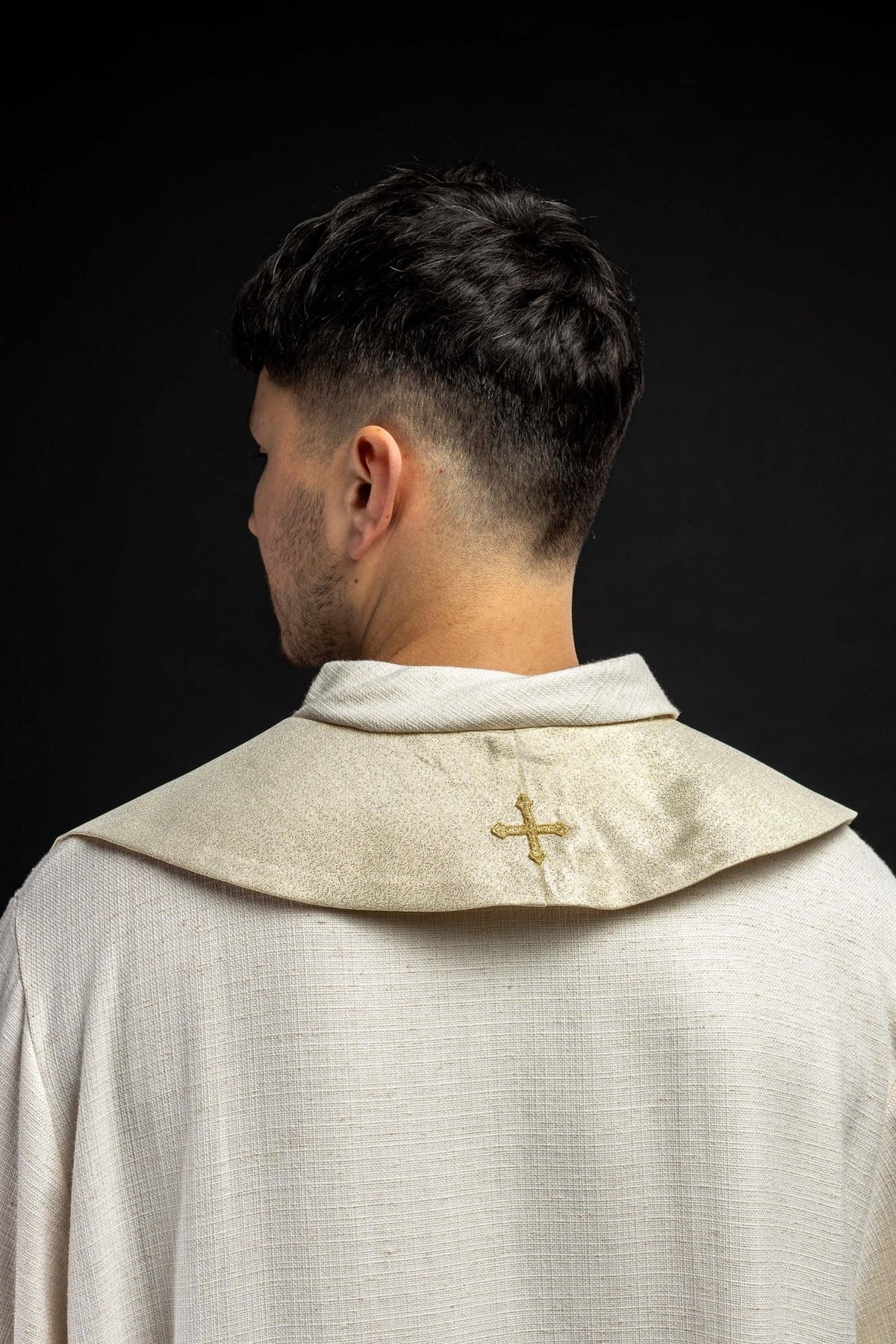 Gold stole worn back view with an embroidered gold cross at the collar