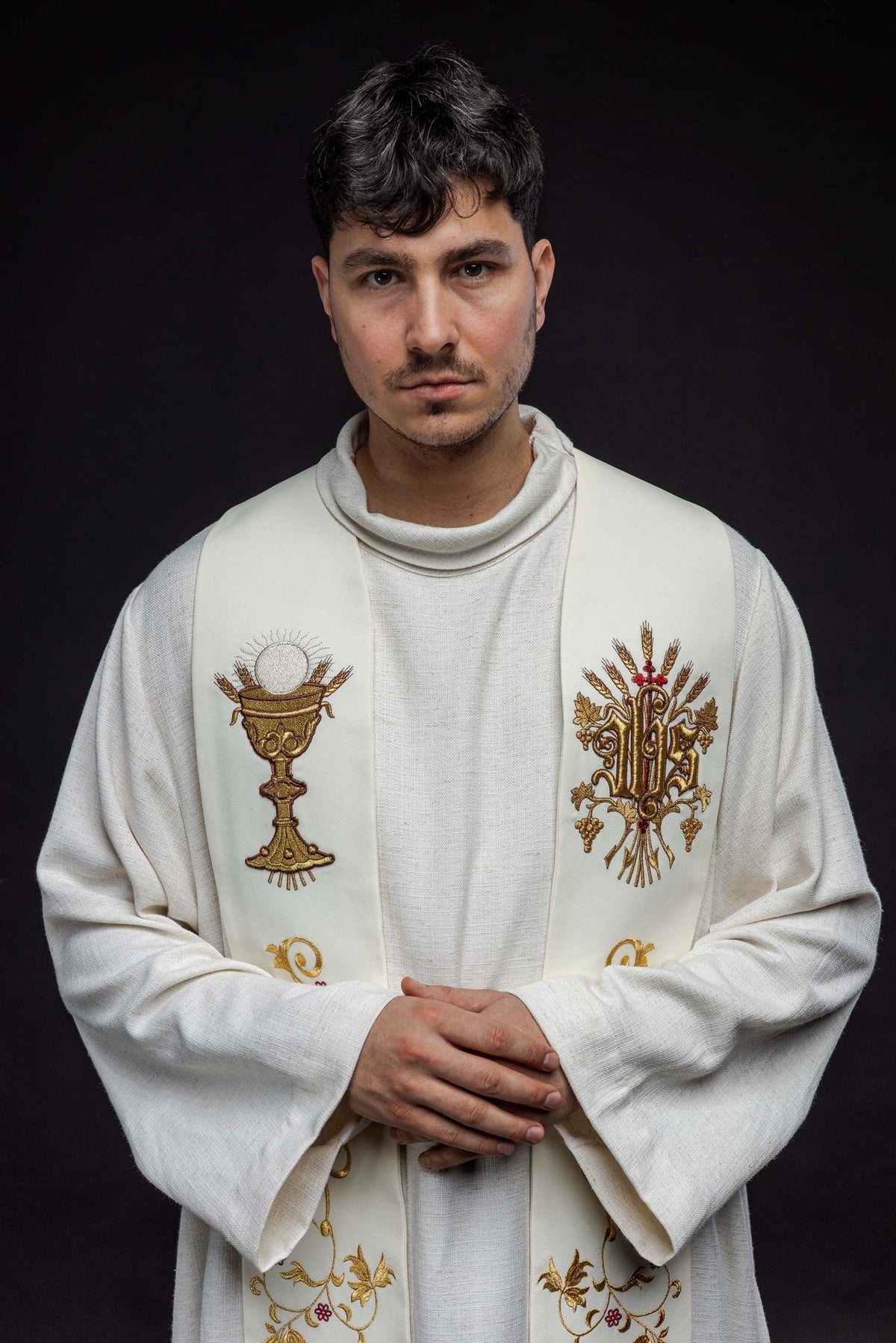 Ecru embroidered stole worn close-up showing IHS and chalice motifs