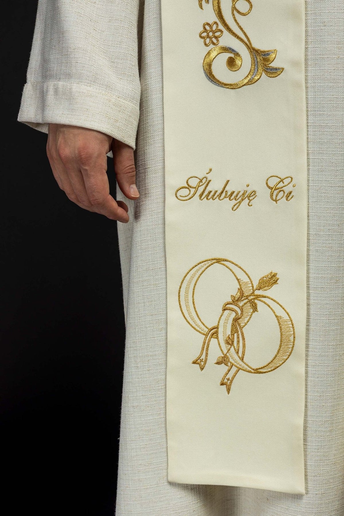 Wedding stole close-up showing cream fabric, gold embroidered wedding rings and script