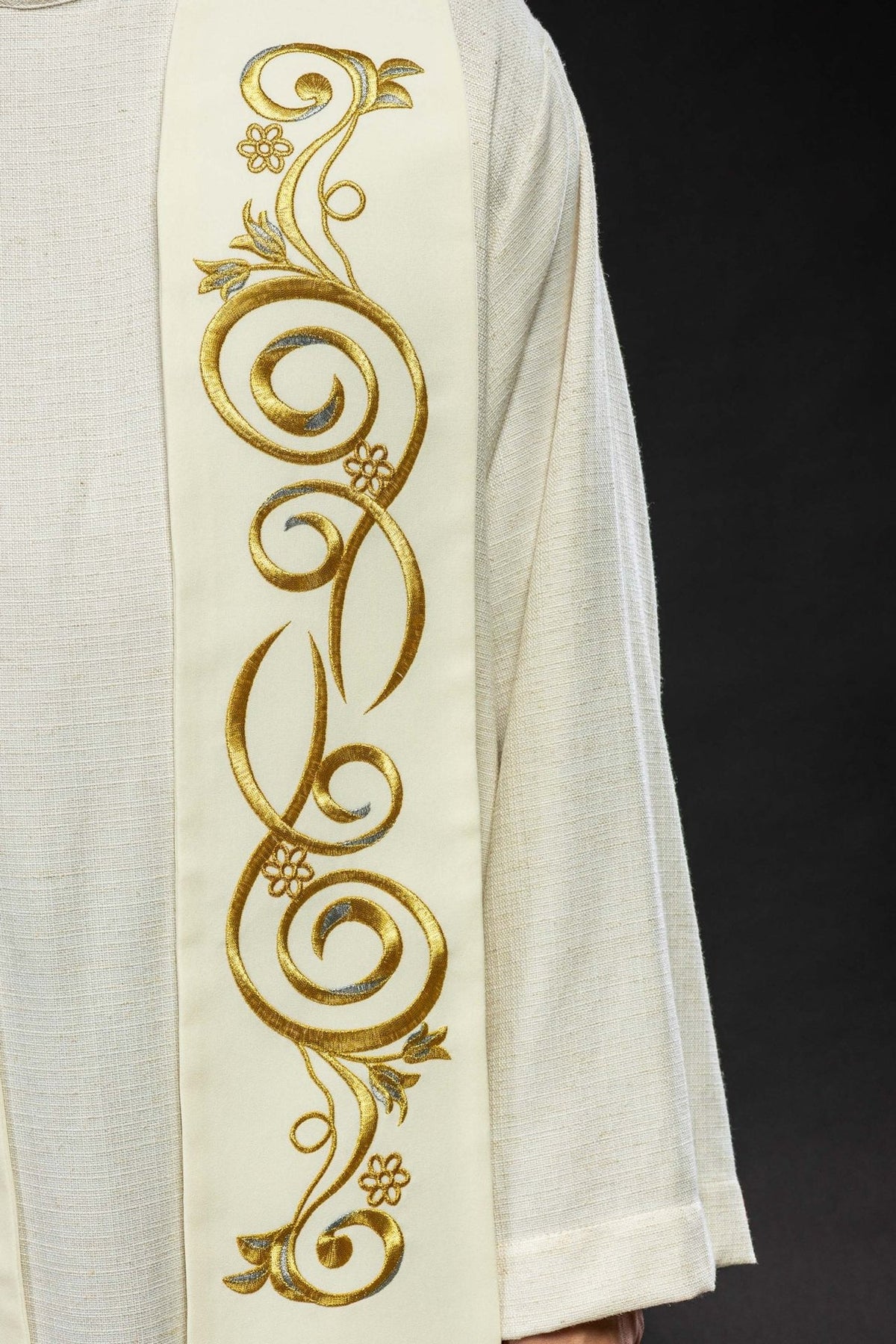 Cream stole close-up showing repeating gold floral scroll embroidery