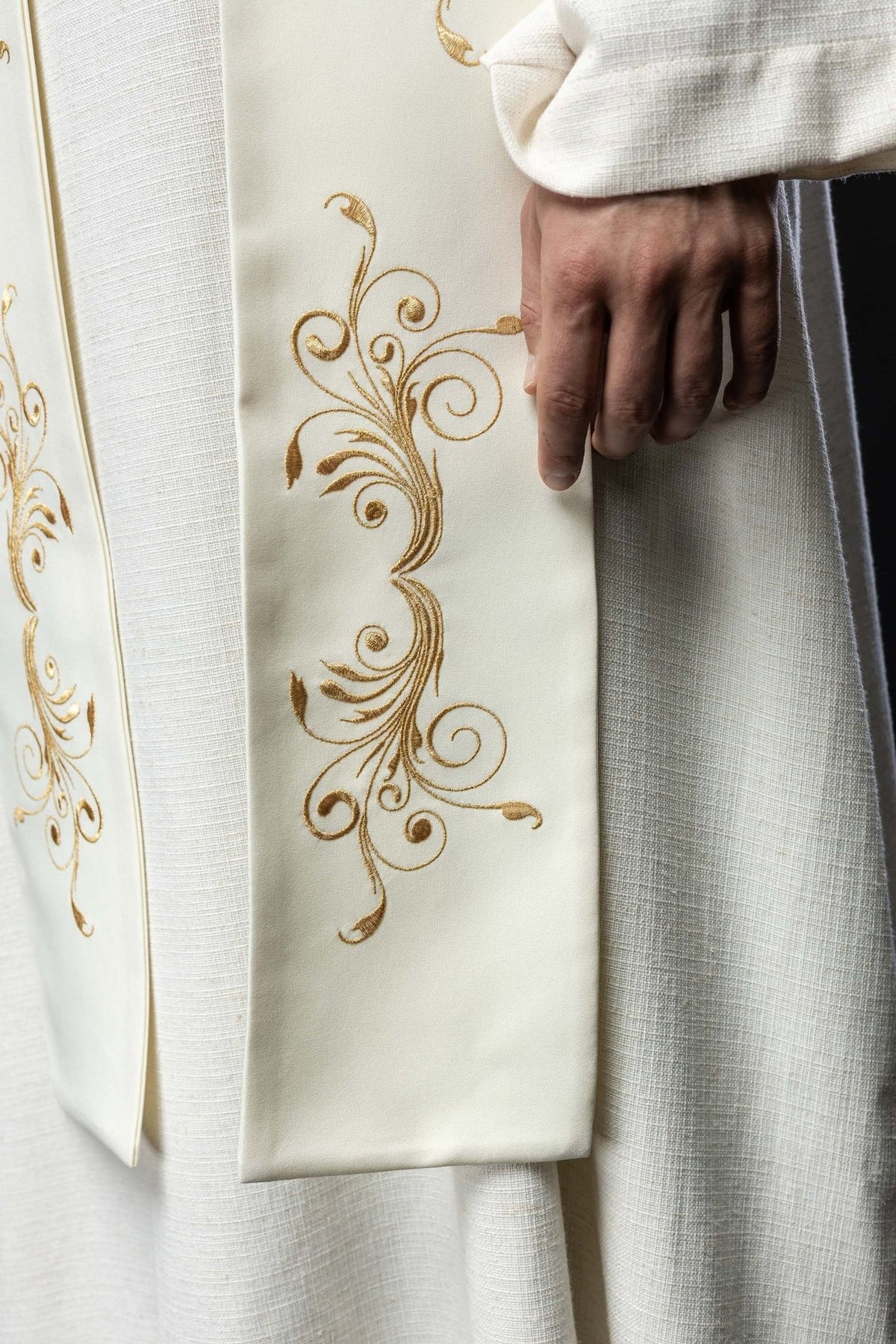 Ecru stole close-up showing gold scroll embroidery on the lower section