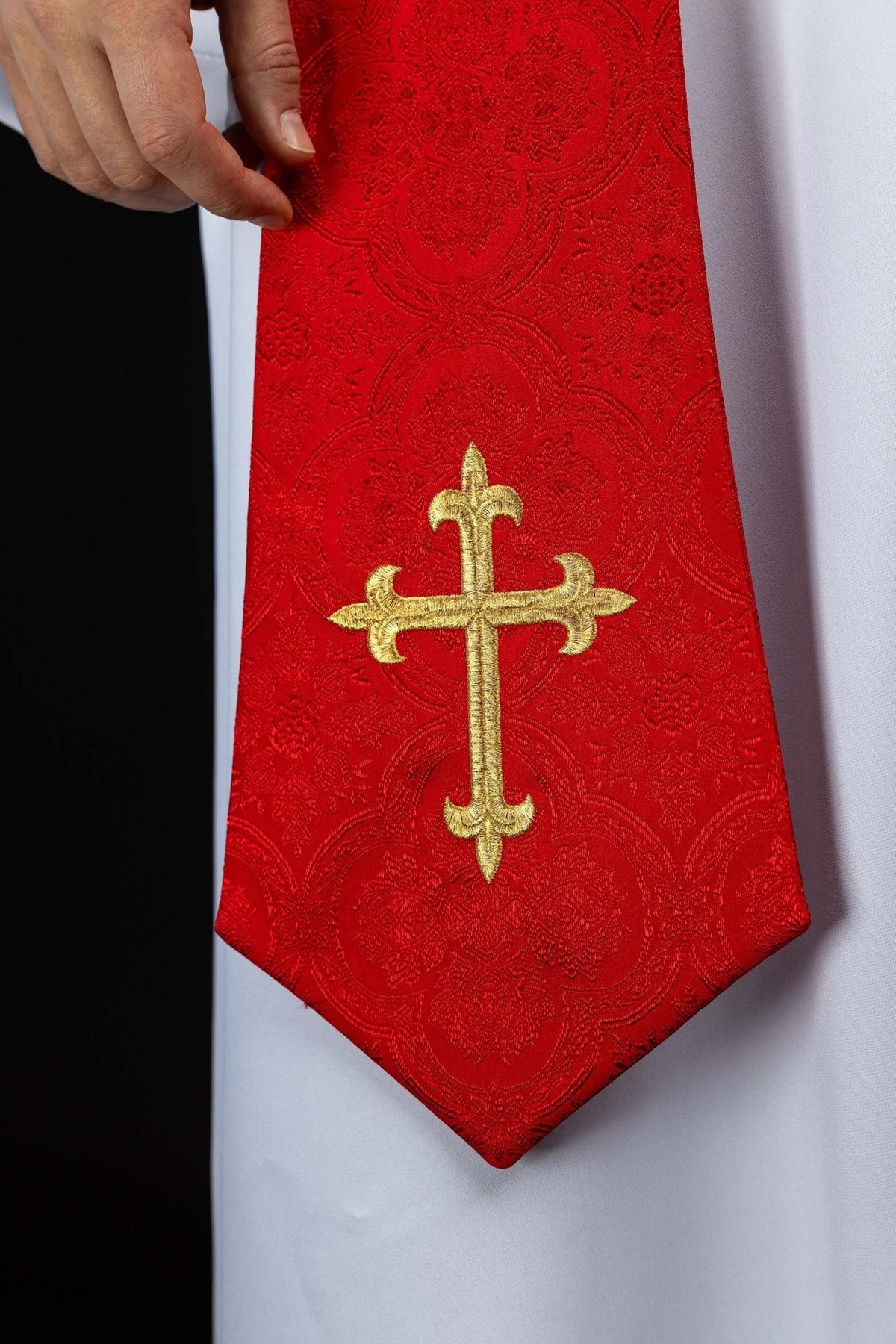 Red stole close-up with gold embroidered cross and jacquard pattern