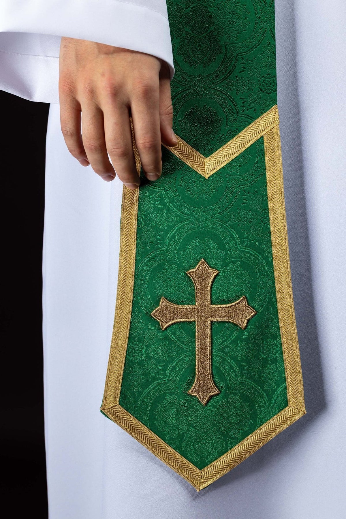 Green embroidered stole close-up with gold cross, gold trim and jacquard pattern