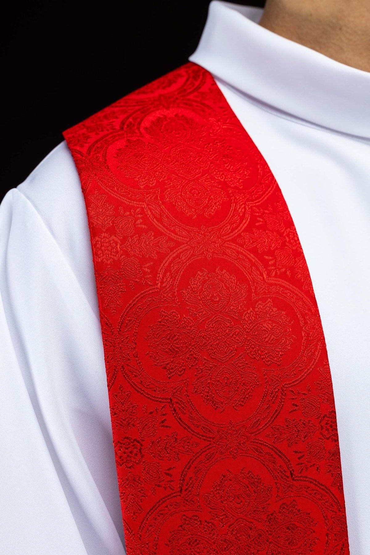 Red stole close-up showing jacquard fabric and gold edging