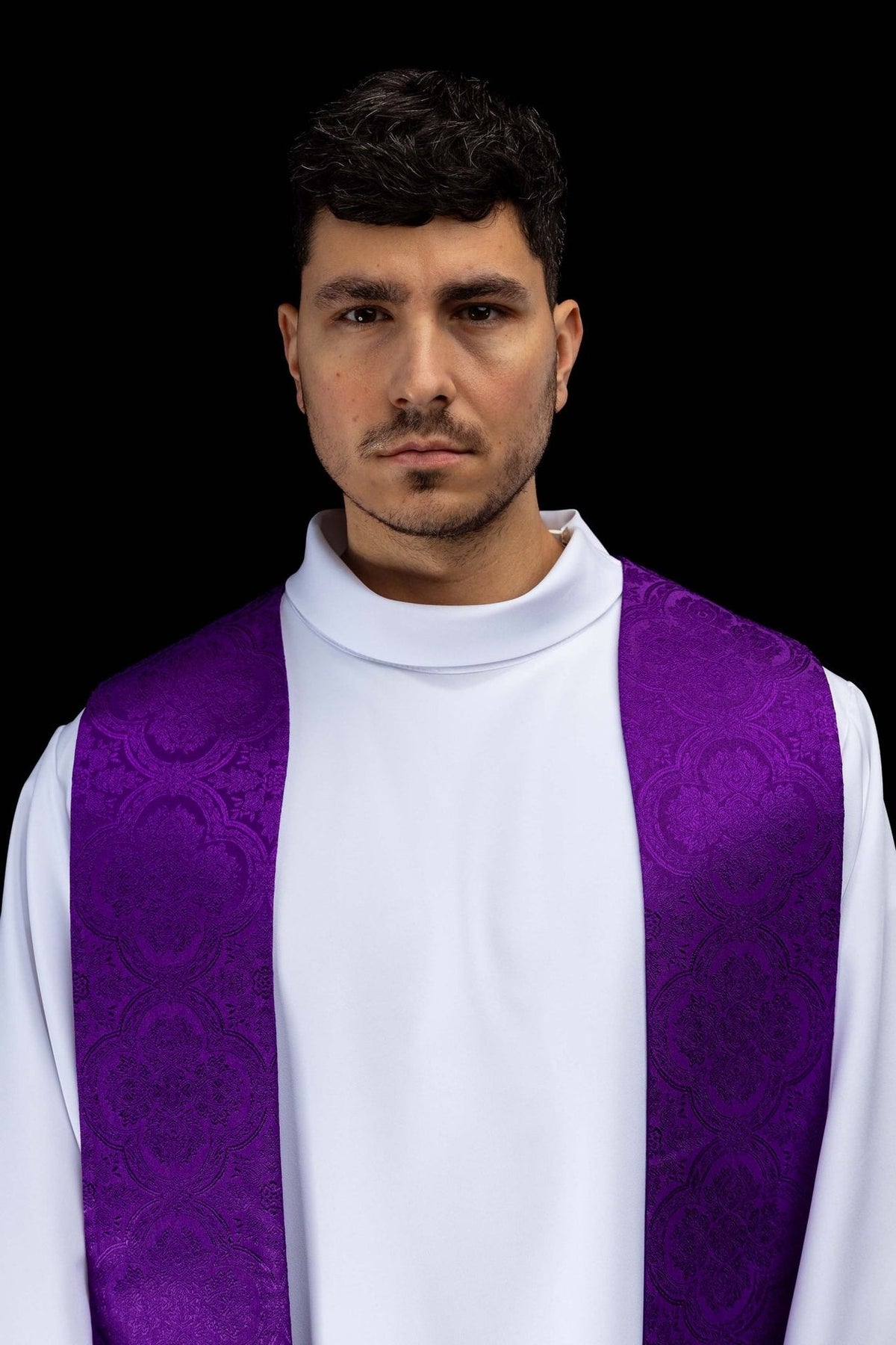 Purple priest stole worn close-up showing jacquard fabric pattern