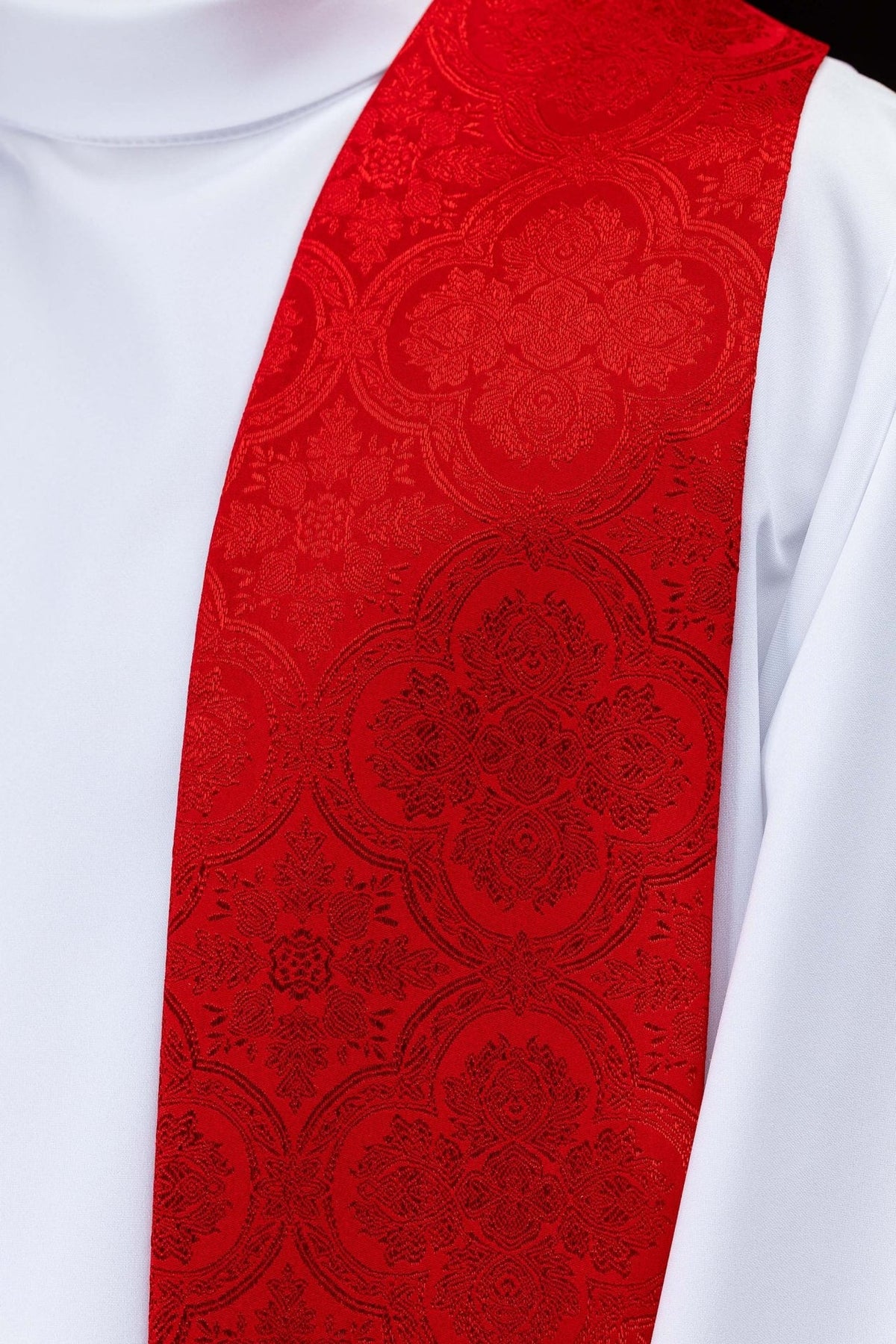 Red jacquard stole close-up showing ornate woven pattern