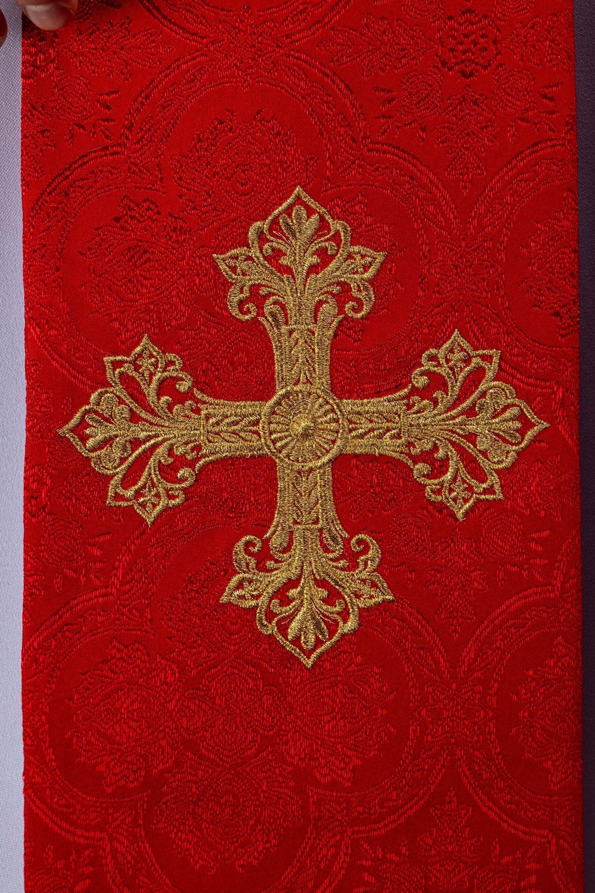 Red embroidered stole detail with gold cross motif