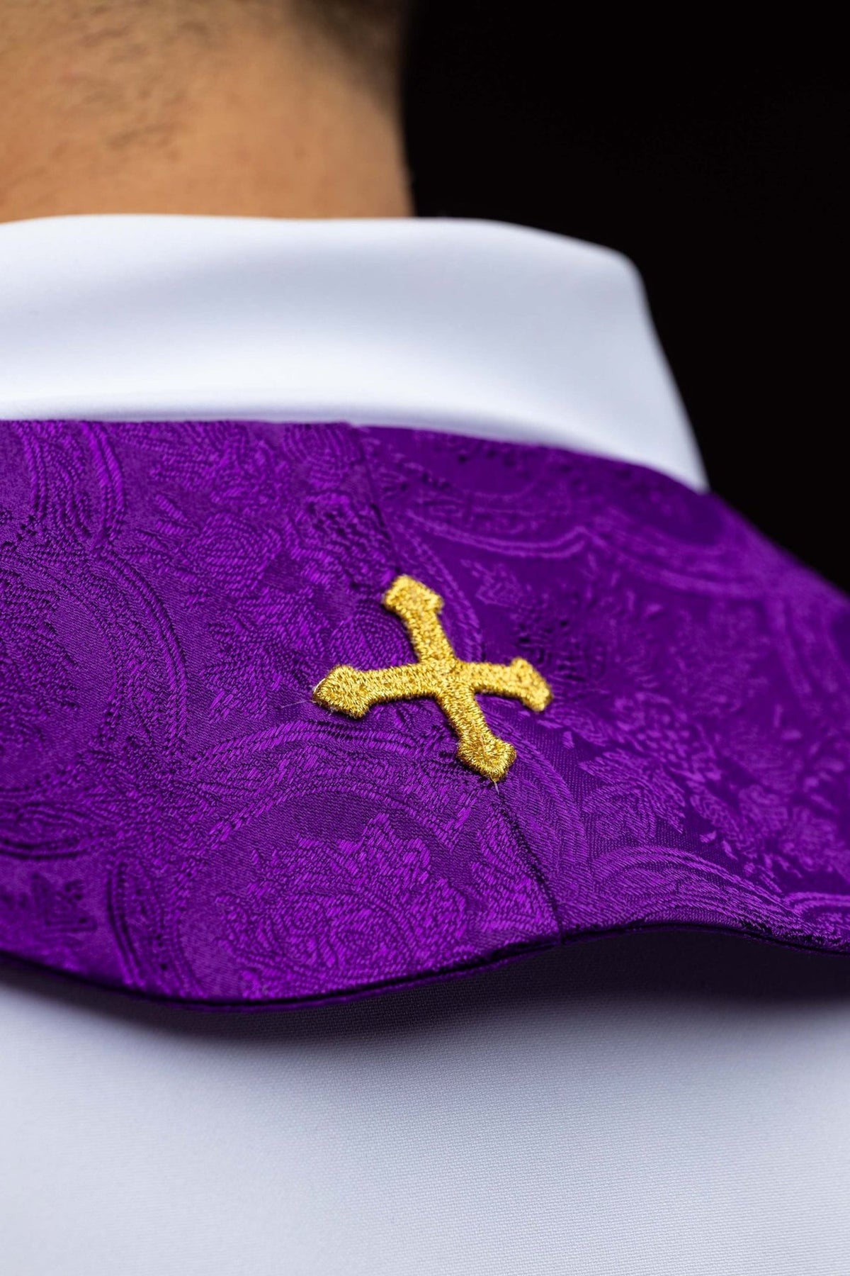 Purple stole detail showing a single gold embroidered cross