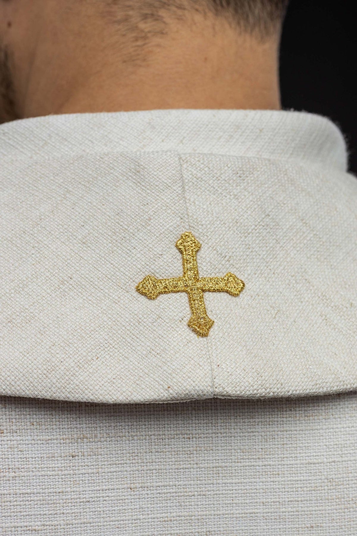 Stole close-up showing gold cross embroidery on white fabric