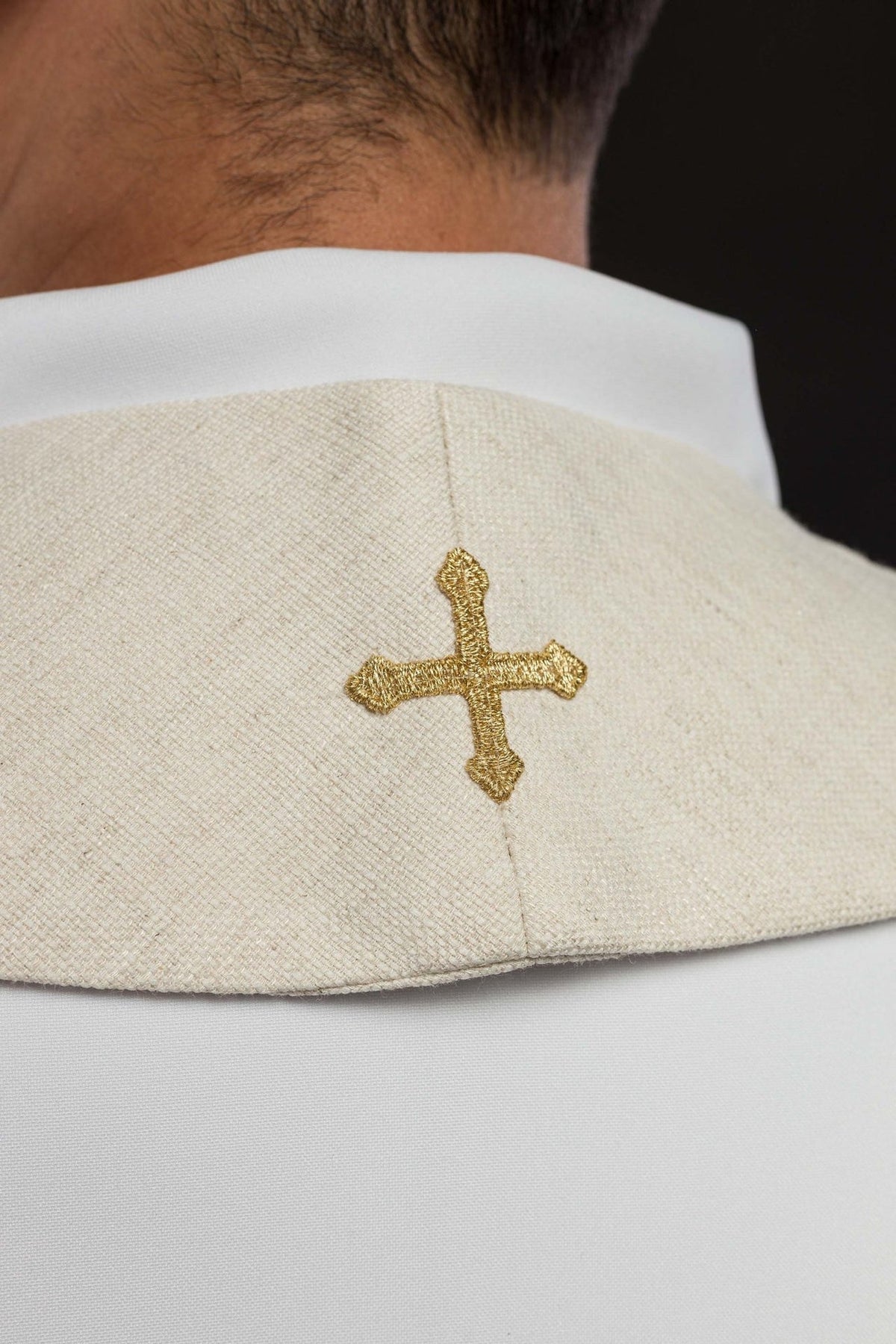 Stole close-up showing a gold embroidered cross on ivory fabric