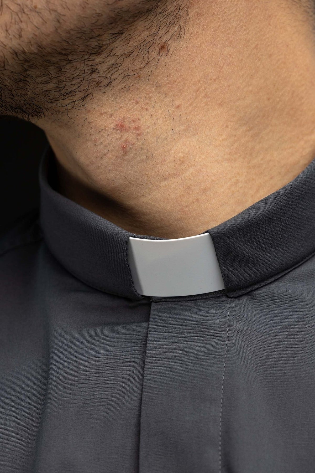 Clergy shirt close-up showing the white clerical collar insert