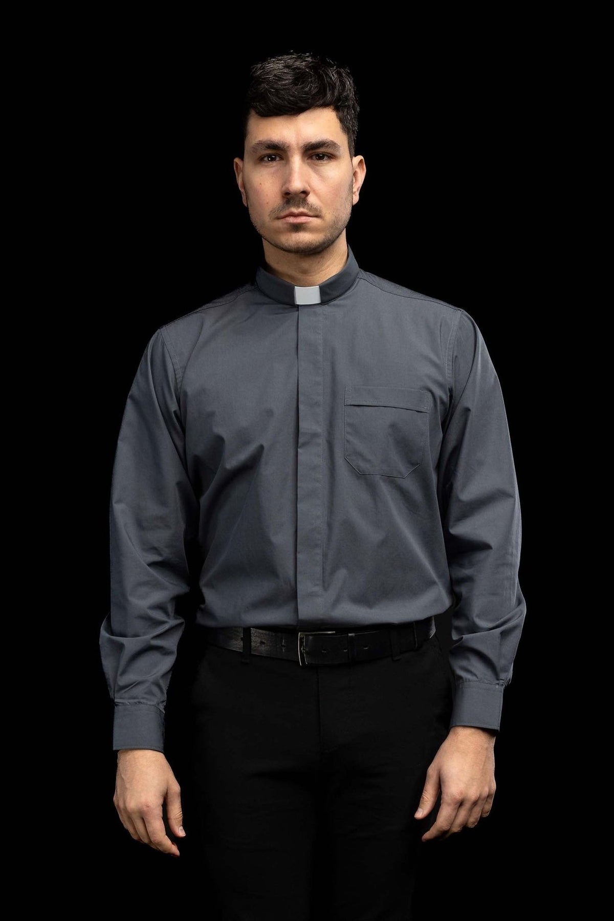 Dark gray clergy shirt worn from the front with long sleeves and chest pocket