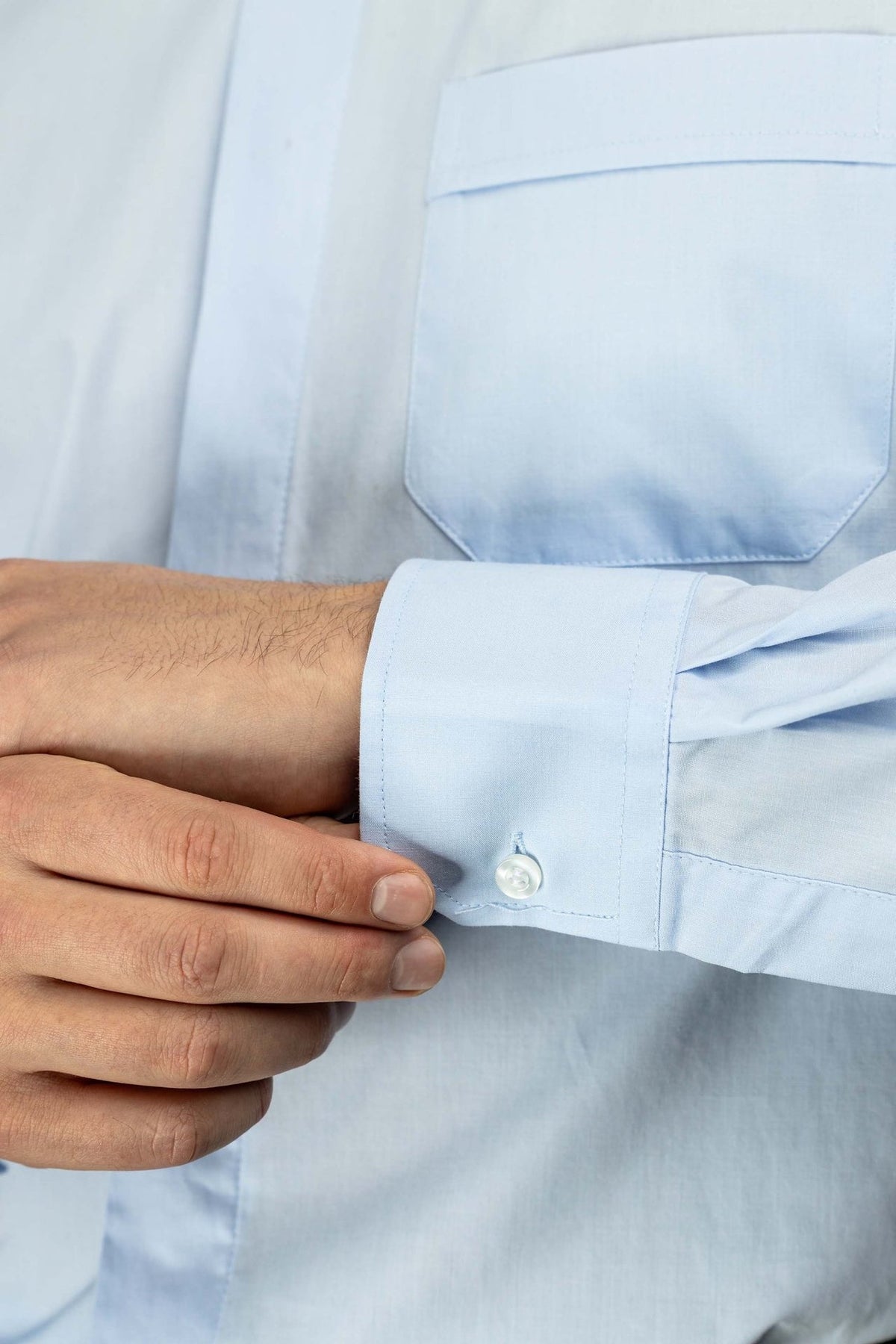 Light blue clergy shirt close-up of long sleeve cuff and button