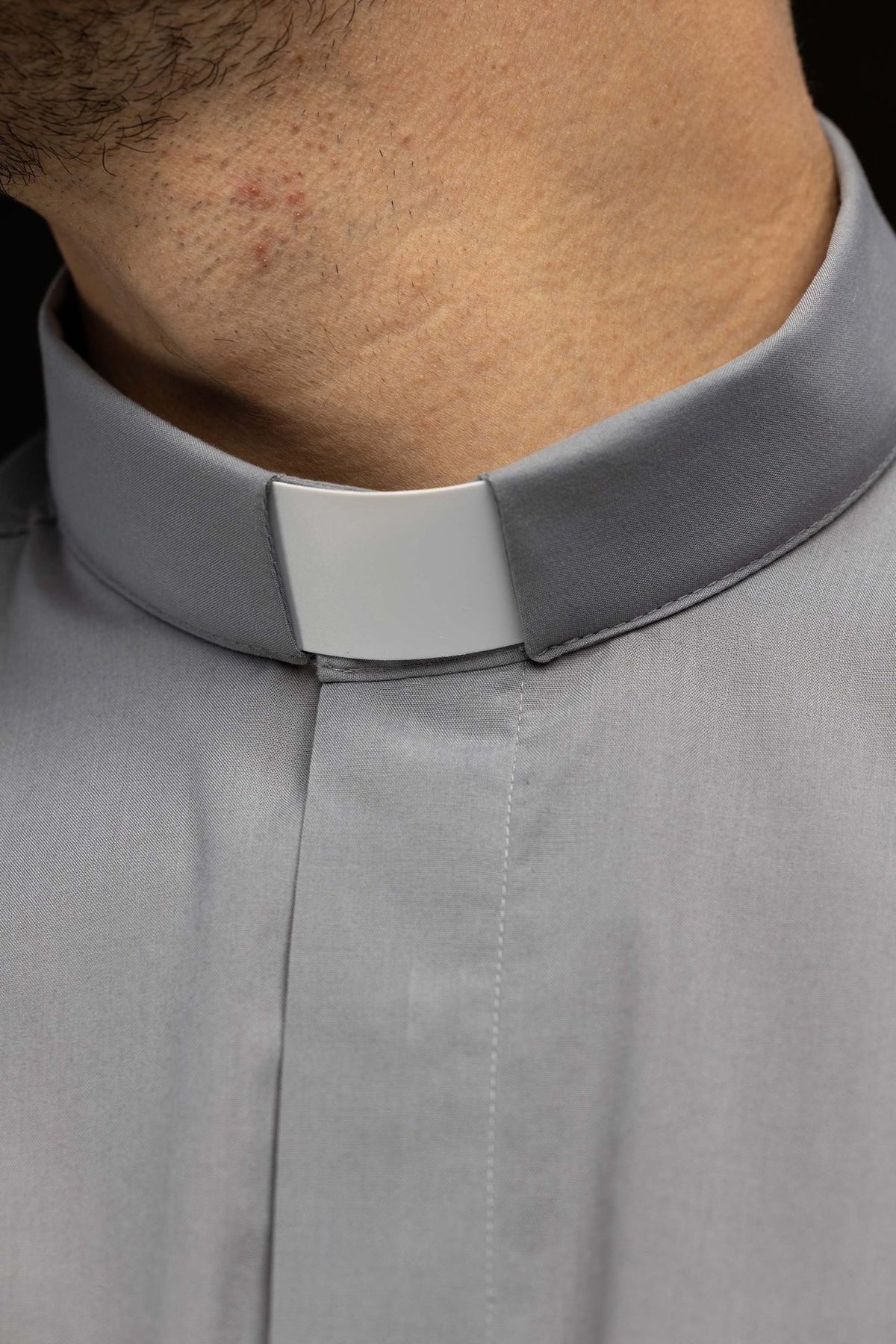 Light gray clergy shirt close-up of clerical collar and front placket