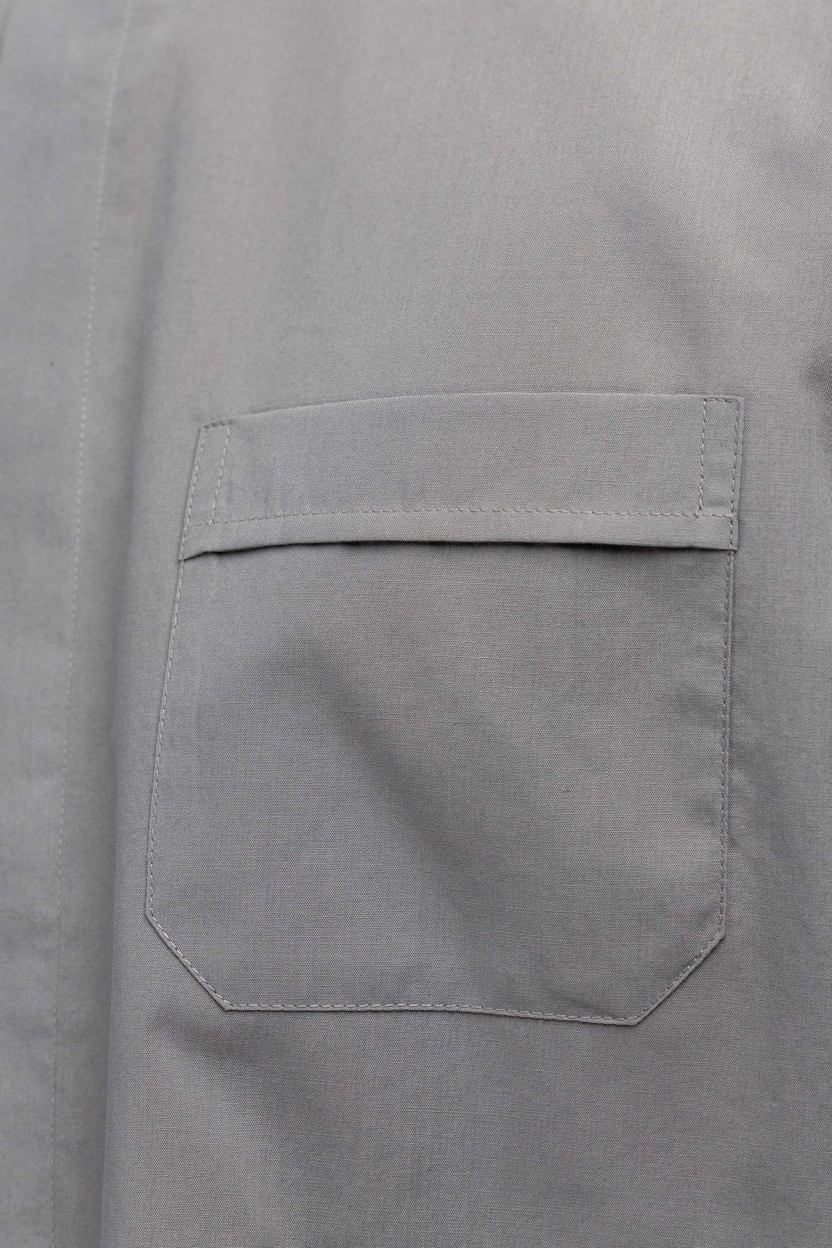 Light gray clergy shirt close-up of flap chest pocket