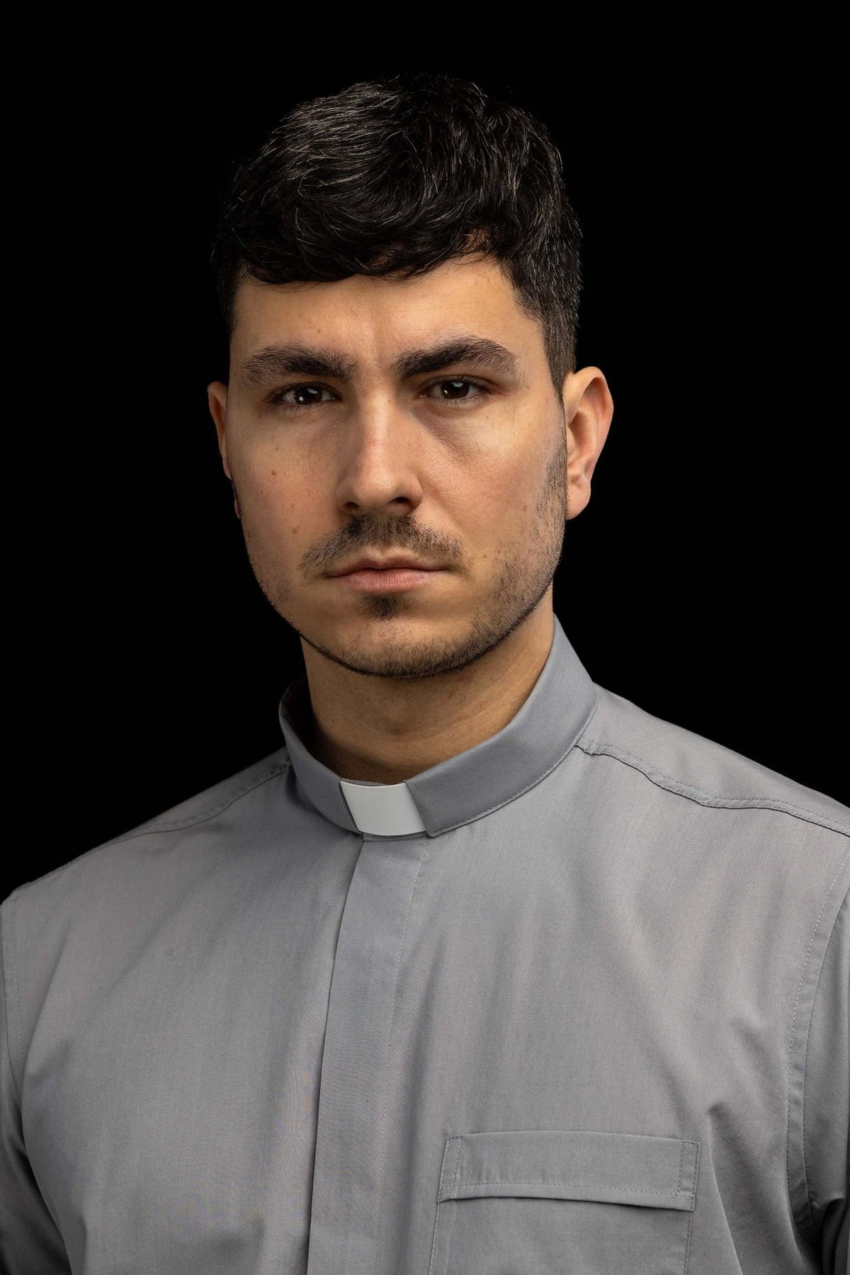 Light gray clergy shirt worn, front view with clerical collar and chest pocket