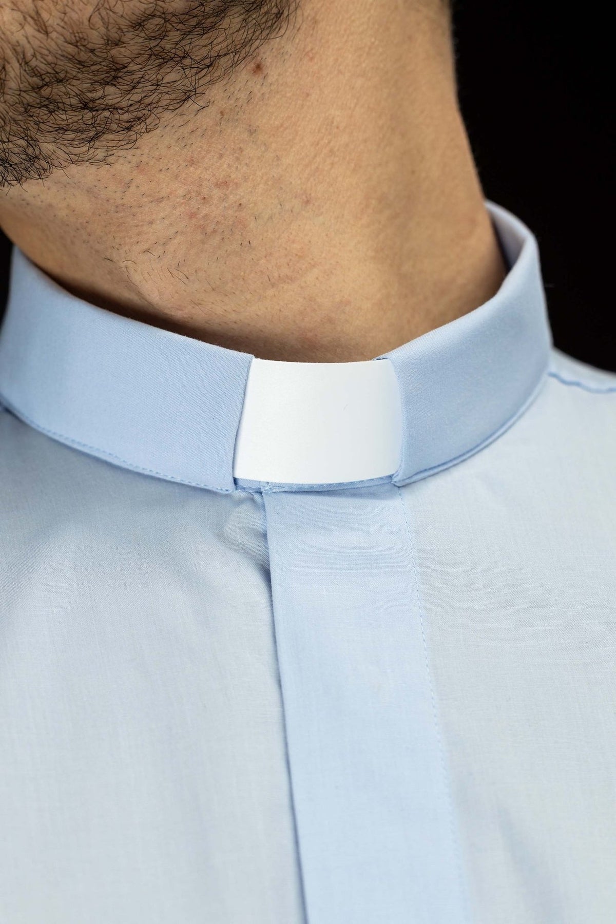 Light blue clergy shirt close-up showing the clerical collar and front placket