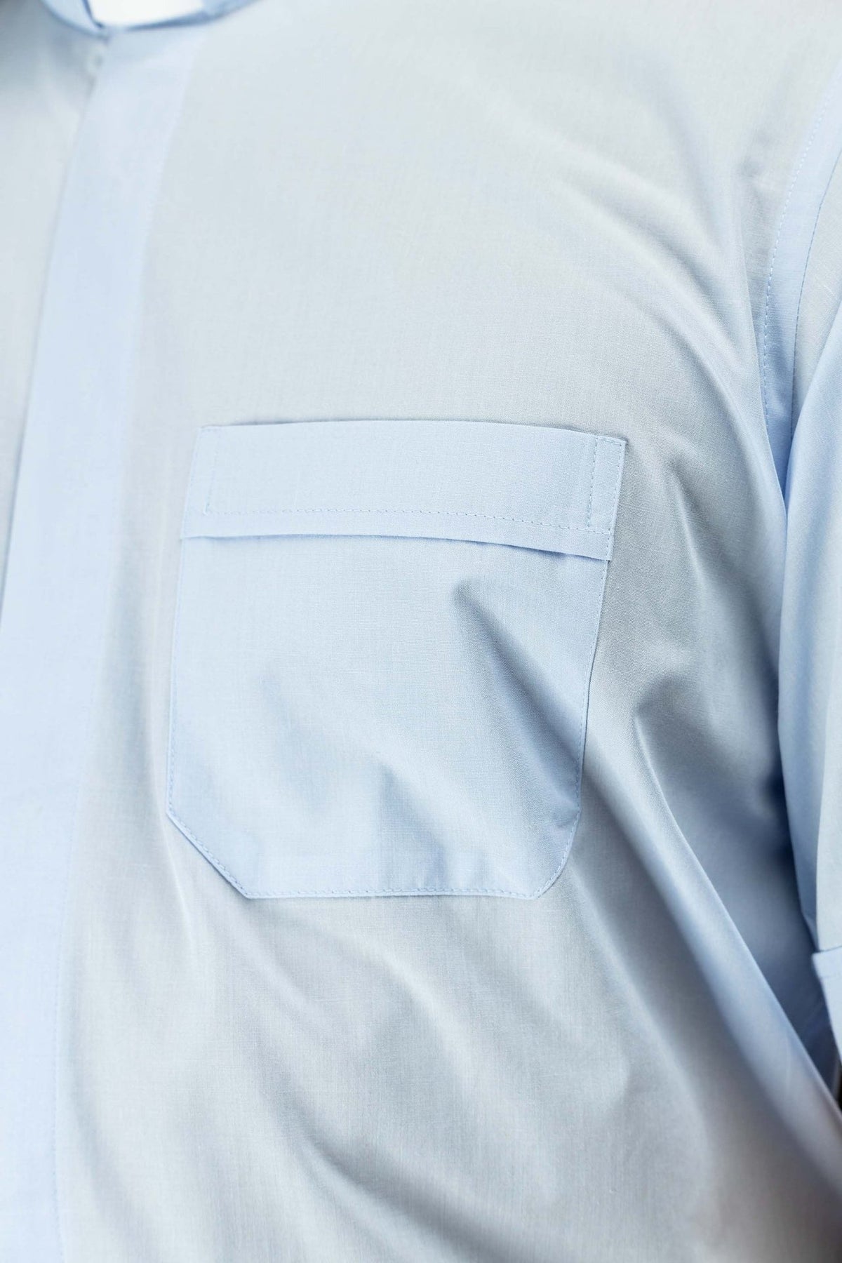 Light blue clergy shirt close-up of the chest pocket with flap