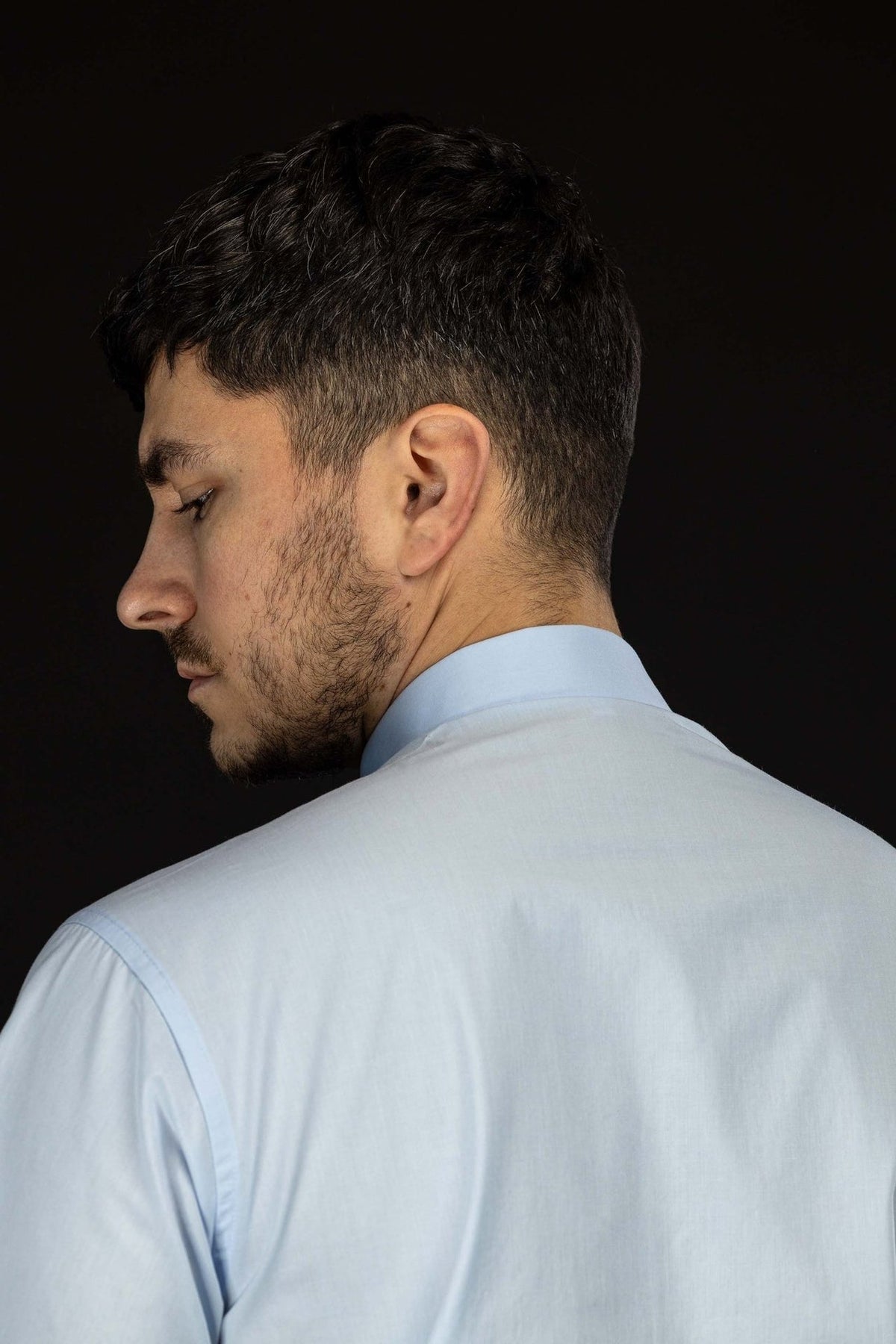Light blue clergy shirt side and back view showing the collar and shoulder seam