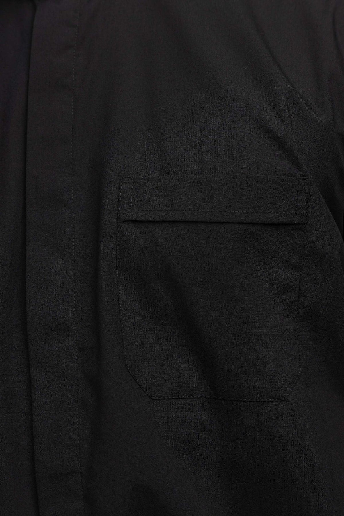 Black clergy shirt close-up showing the flap chest pocket