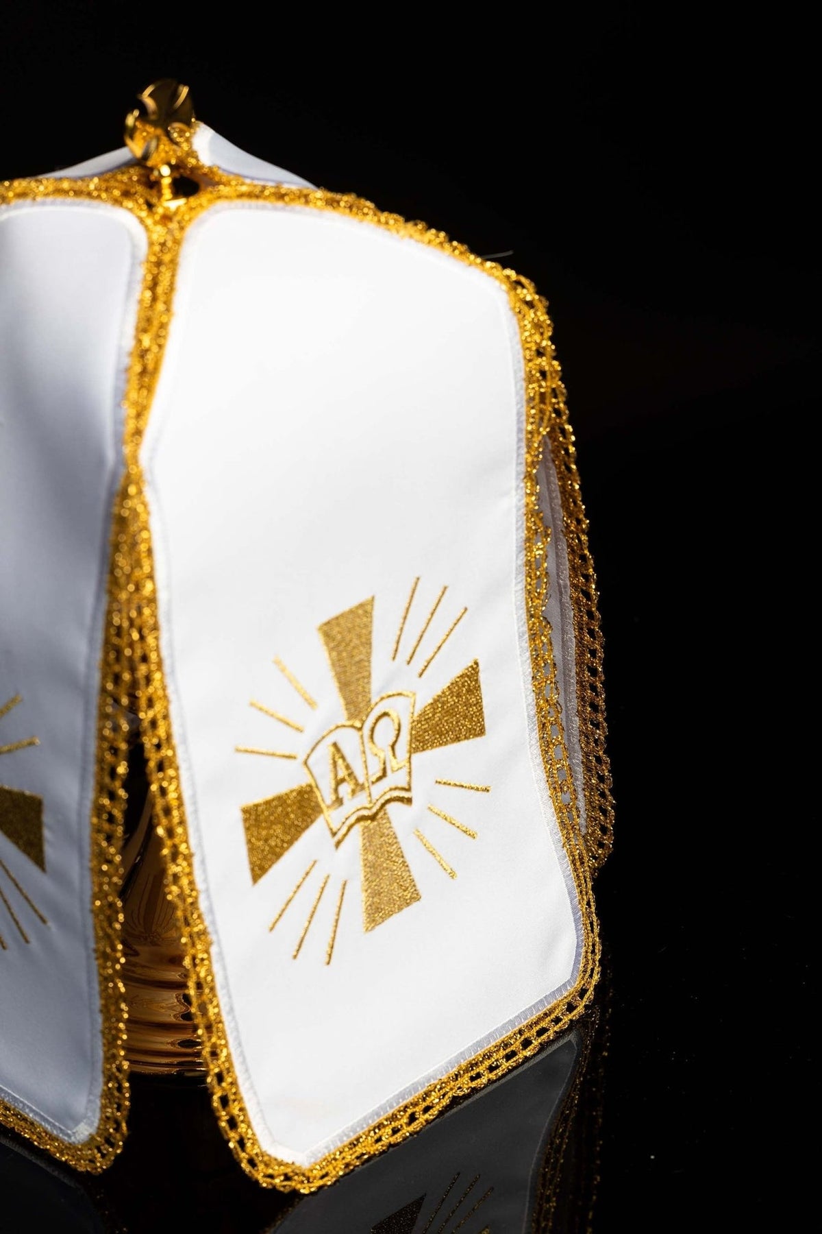 Ciborium veil angled close-up showing white panel with gold Alpha Omega embroidery and trim