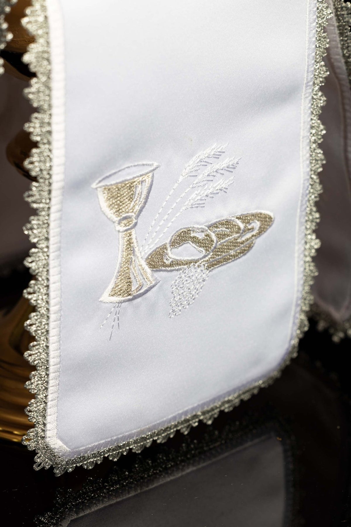 Ciborium veil close-up showing silver Eucharistic embroidery with chalice, altar bread and wheat