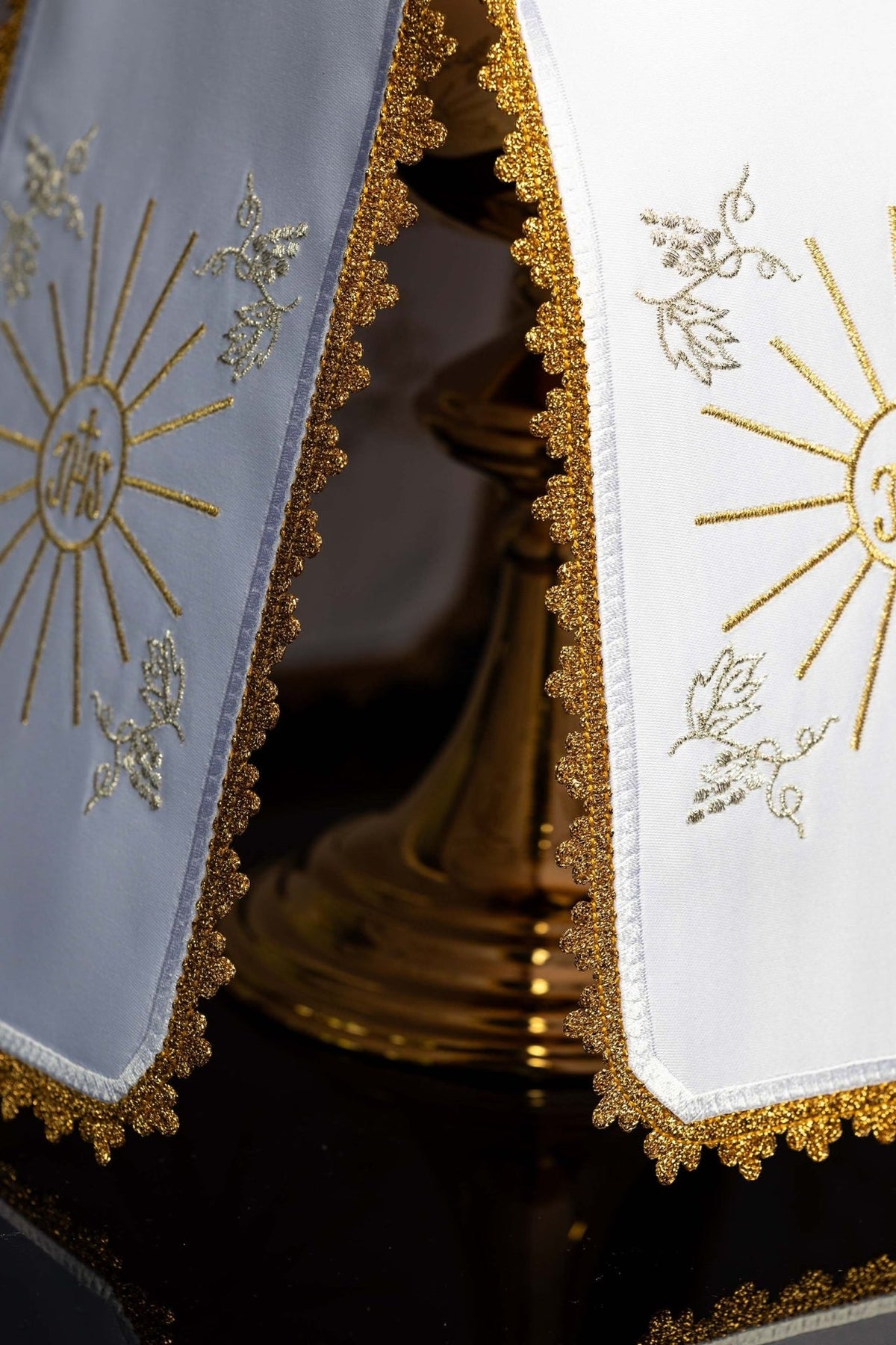 Ciborium veil detail showing white and pale blue panels with gold embroidery and scalloped edging