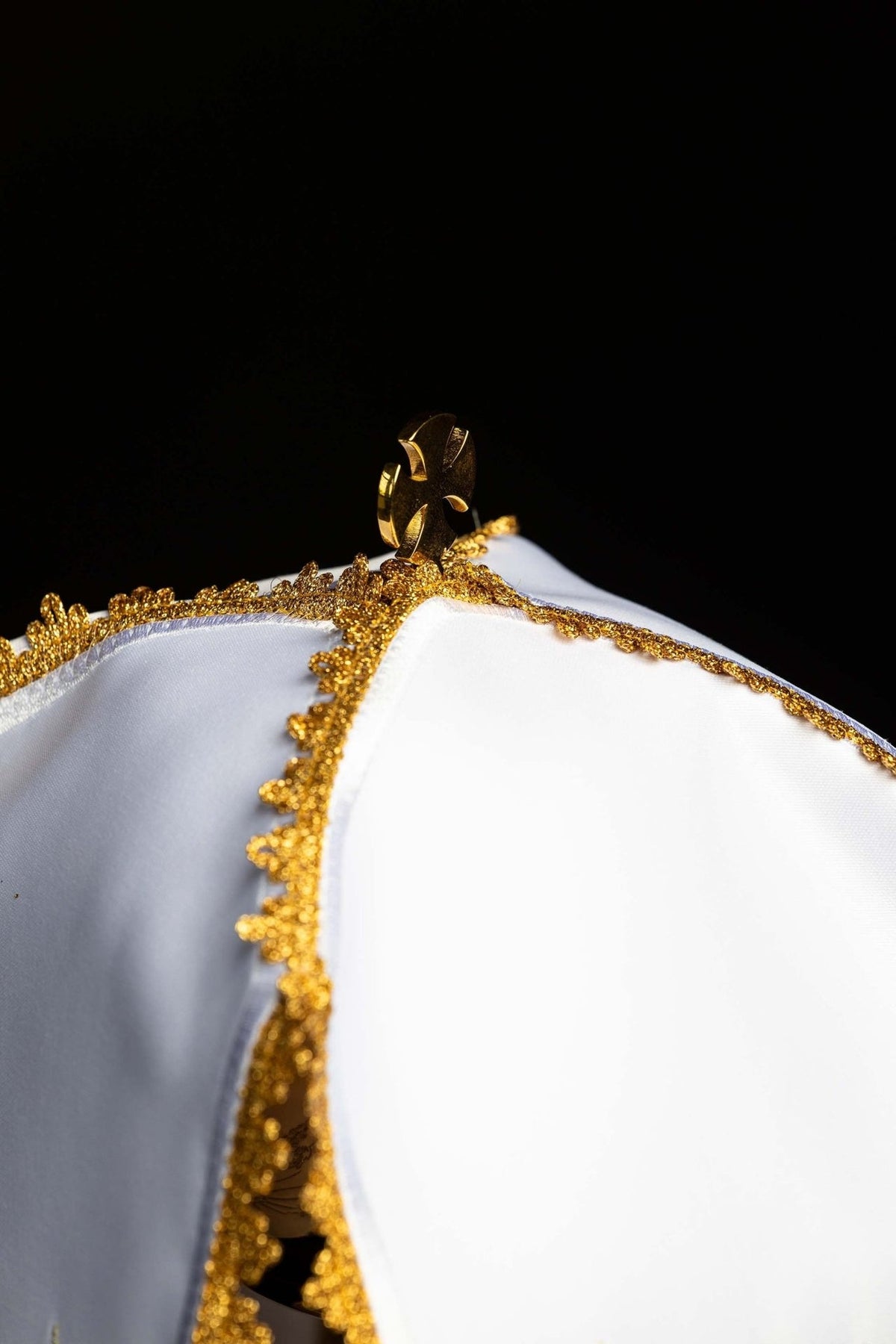 Ciborium veil close-up showing white fabric, gold trim and top fastener