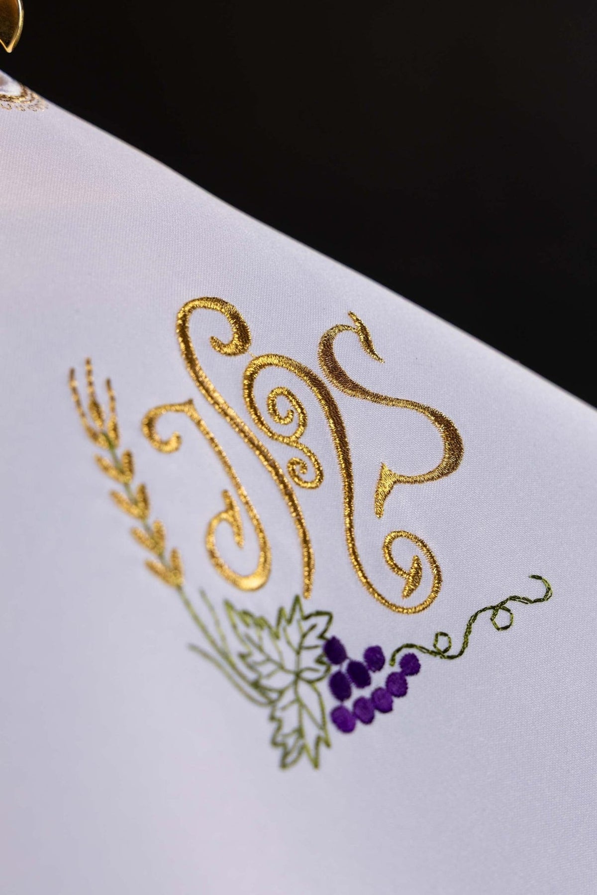 Ciborium veil close-up showing gold IHS, grapes and wheat embroidery on white fabric