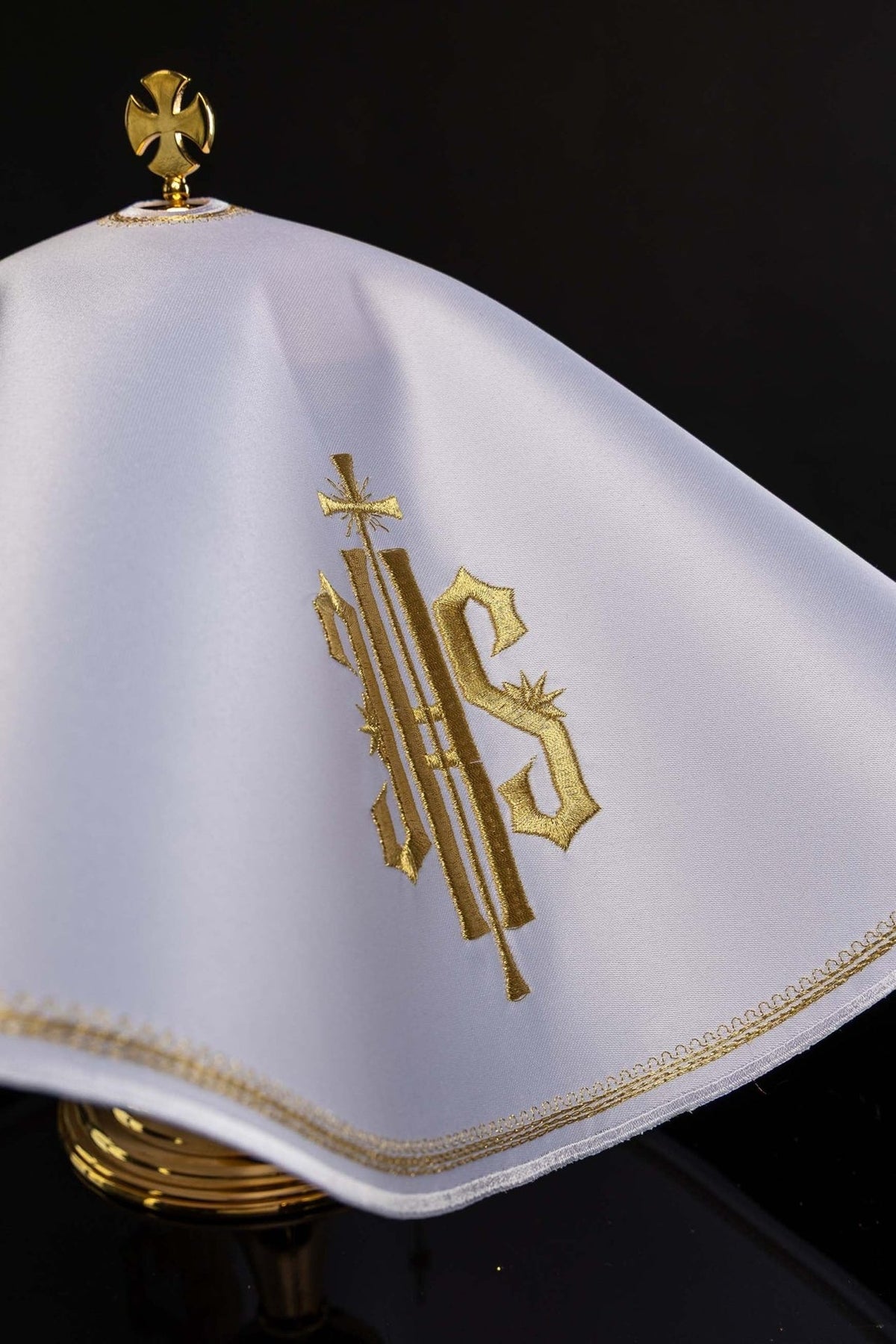 Ciborium veil angled view showing white fabric, gold IHS embroidery and edging
