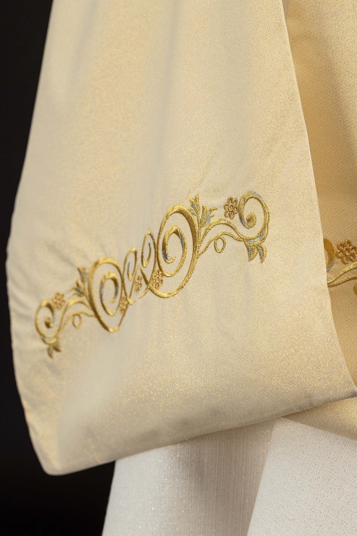 Humeral veil close-up of gold embroidered scrollwork on cream fabric