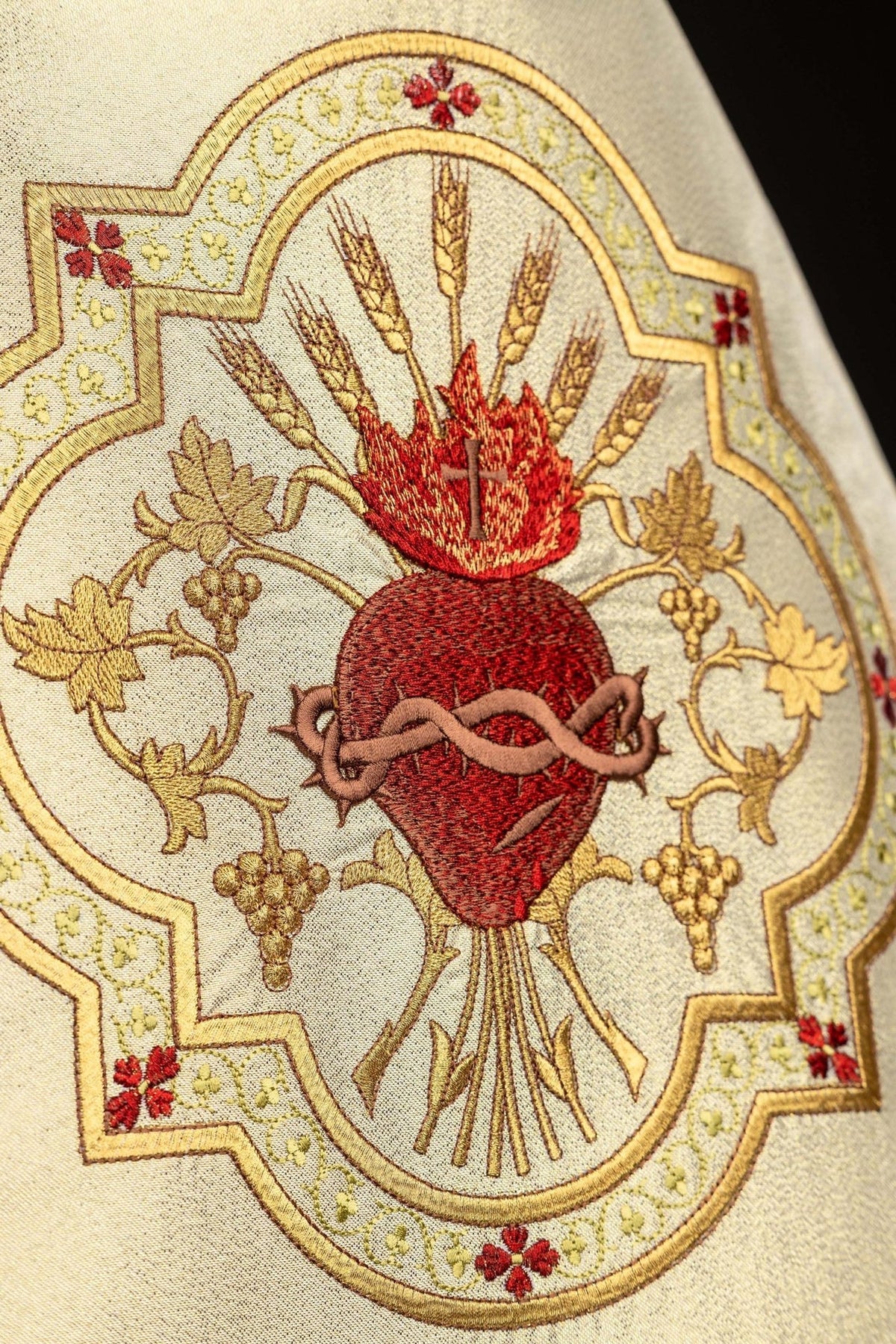 Gold humeral veil close-up showing Sacred Heart of Jesus embroidery with grapes and wheat