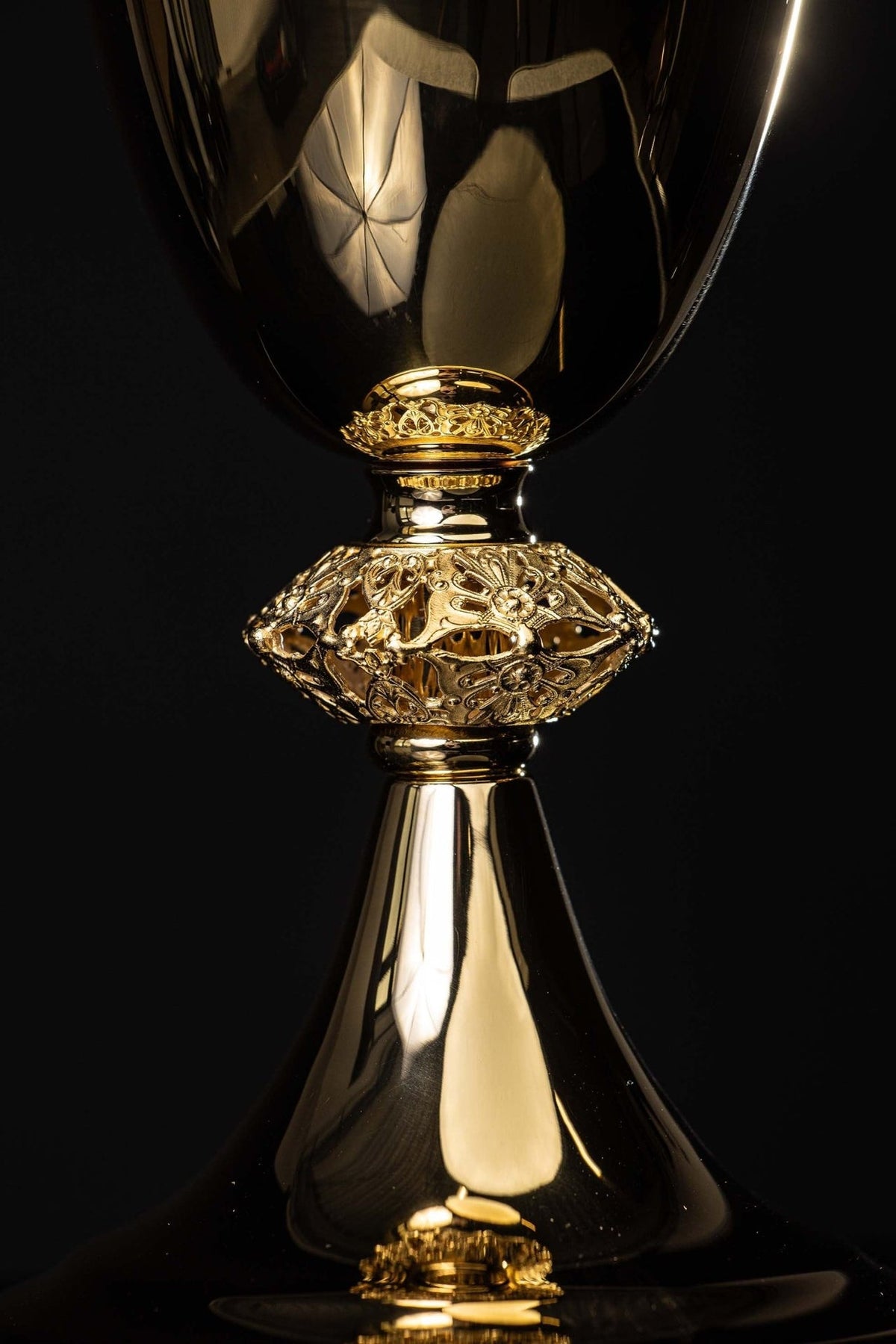Gold-plated brass chalice close-up showing ornate floral stem and smooth cup