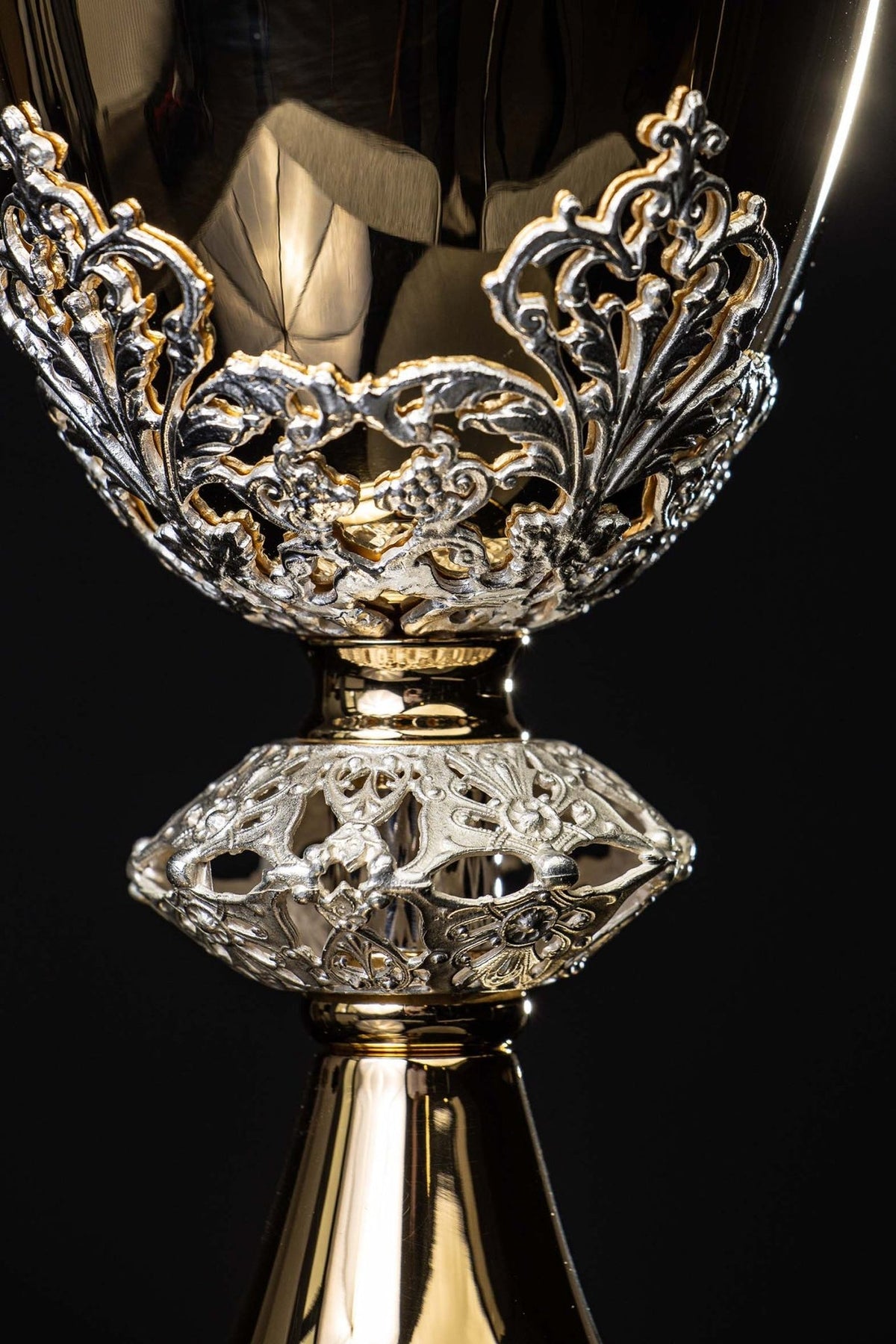 Gold-plated brass chalice close-up showing silver floral embellishments on the cup and stem