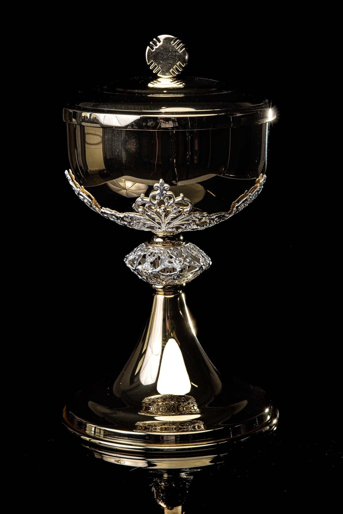Ciborium close-up showing gold lid and circular cross finial