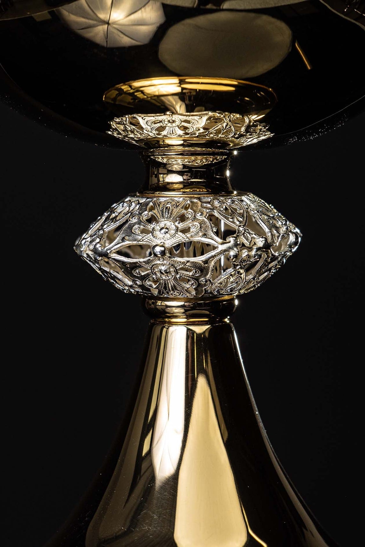 Ciborium close-up showing ornate silver-tone floral detailing on the stem and bowl support