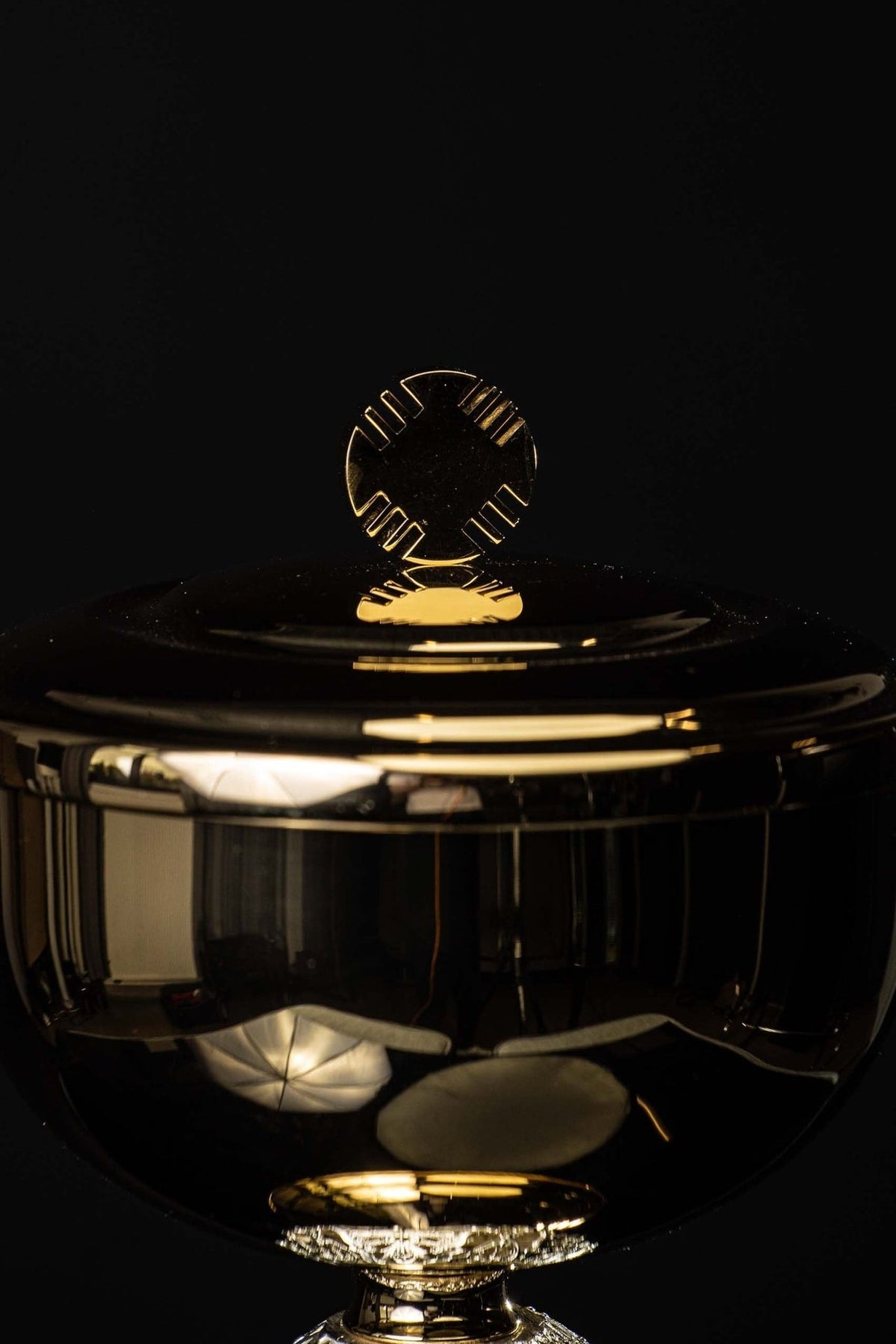 Ciborium close-up showing the polished lid and gold cross finial