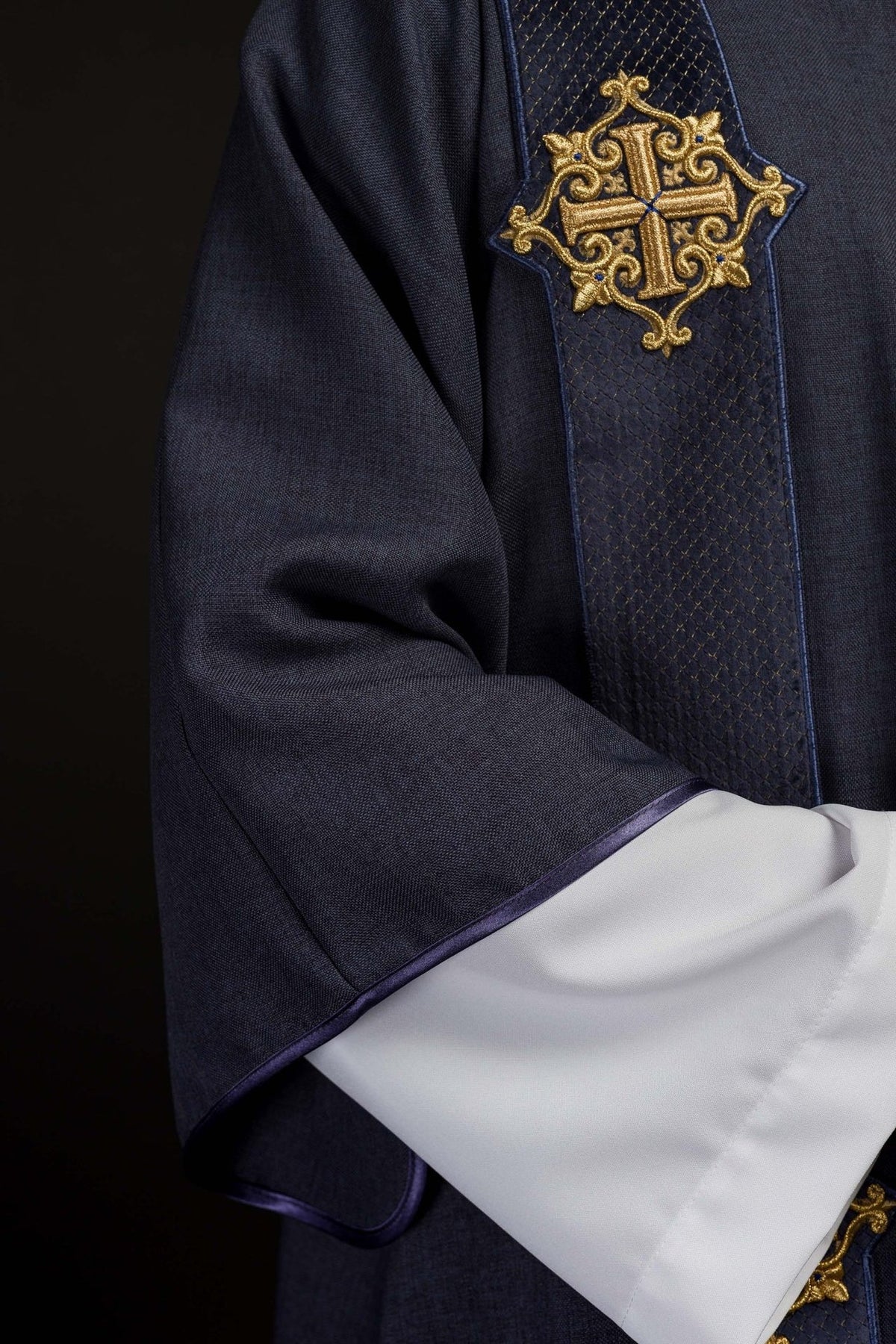 Purple velvet dalmatic close-up showing embroidered cross and quilted orphrey