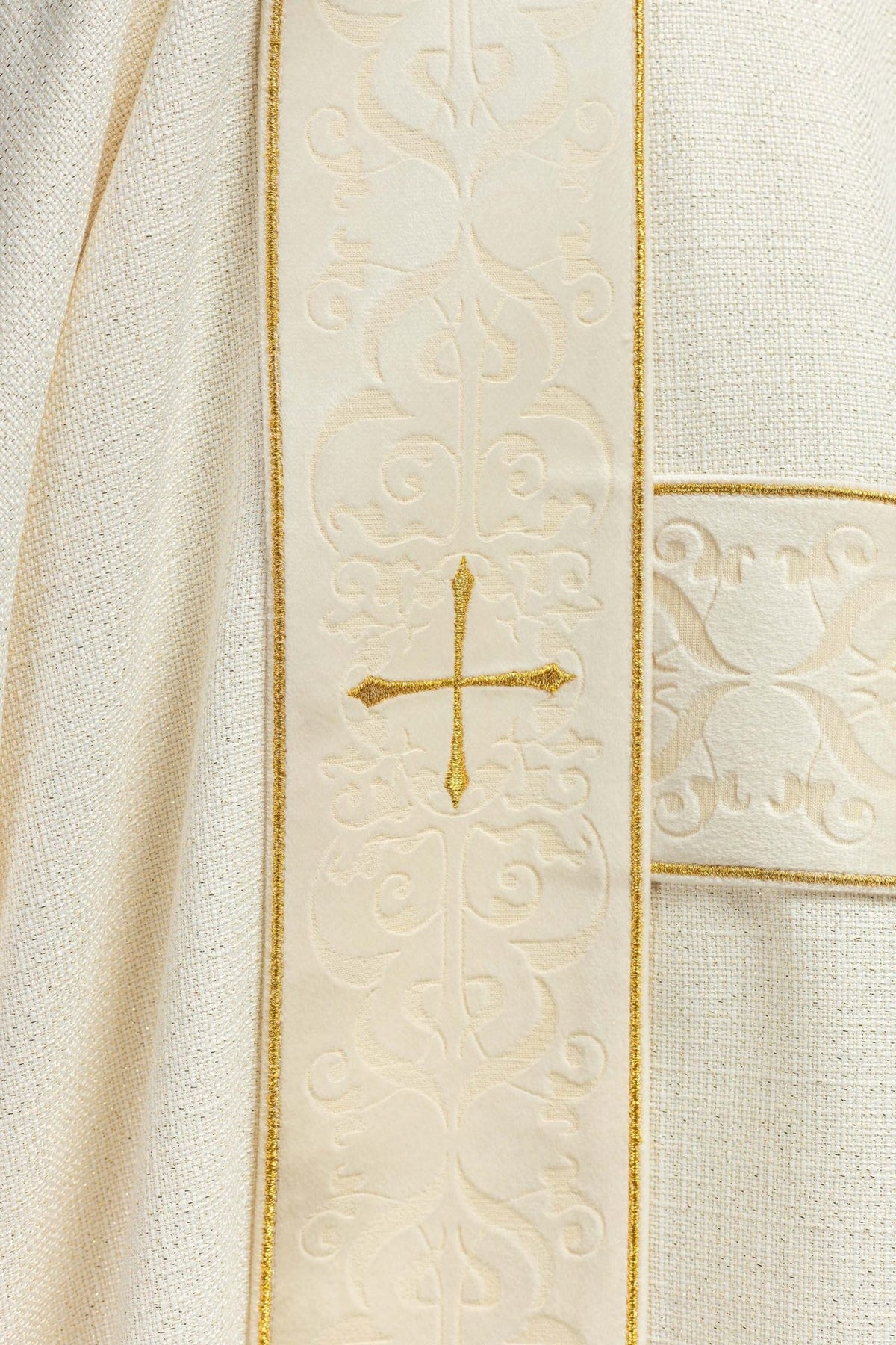 Ecru dalmatic velvet orphrey close-up with embroidered gold cross