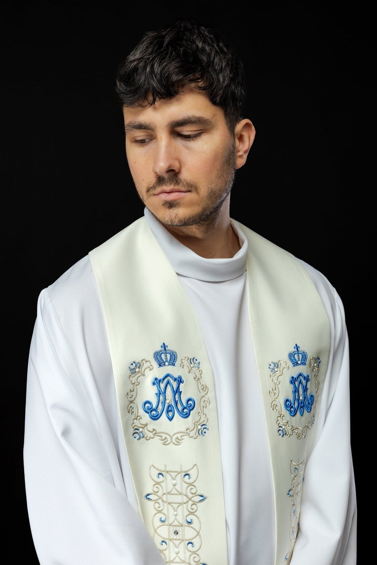Marian stole worn close-up showing blue Marian symbols, crowns and ornate embroidery