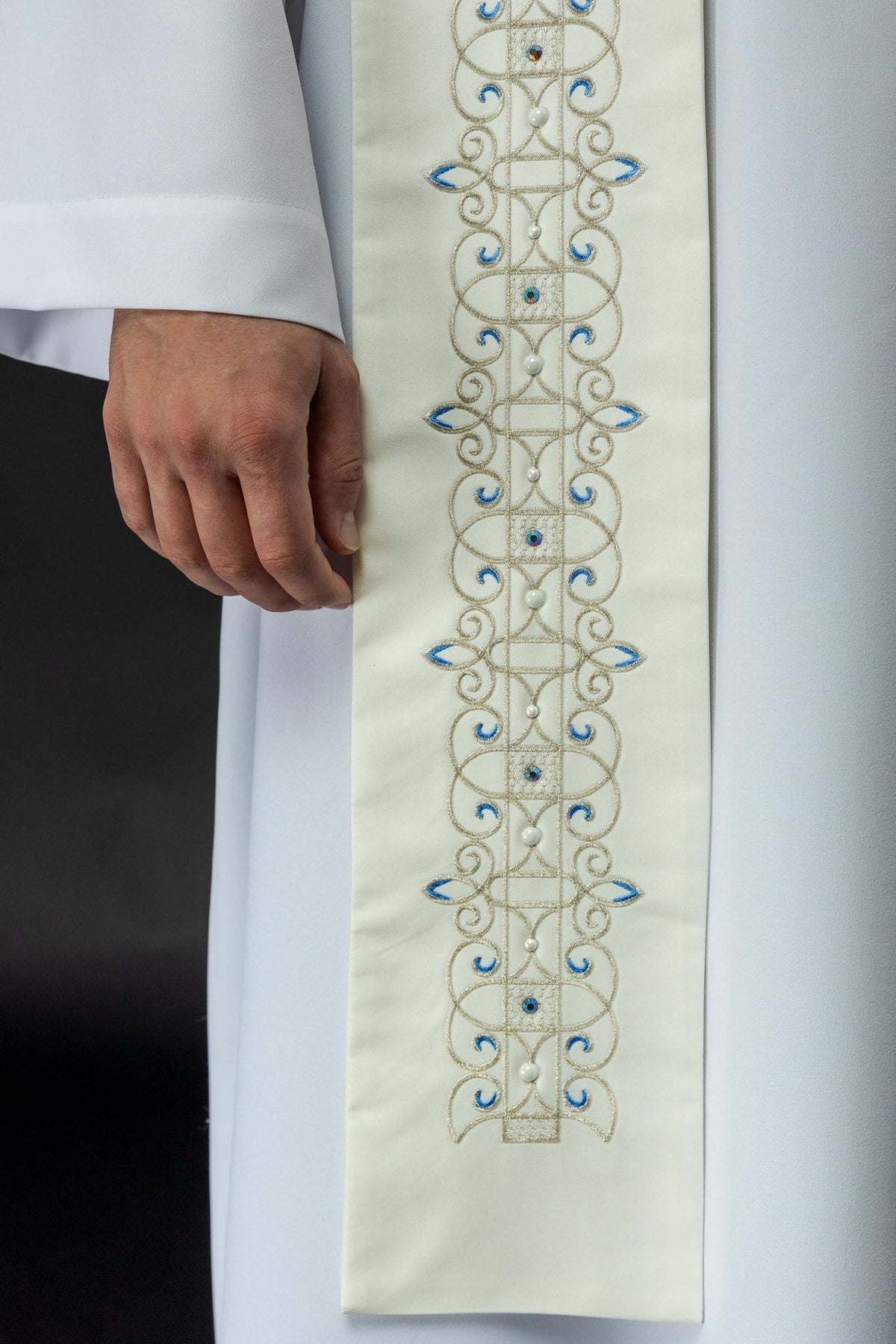 Marian stole close-up showing repeating blue and gold scroll embroidery with pearl accents